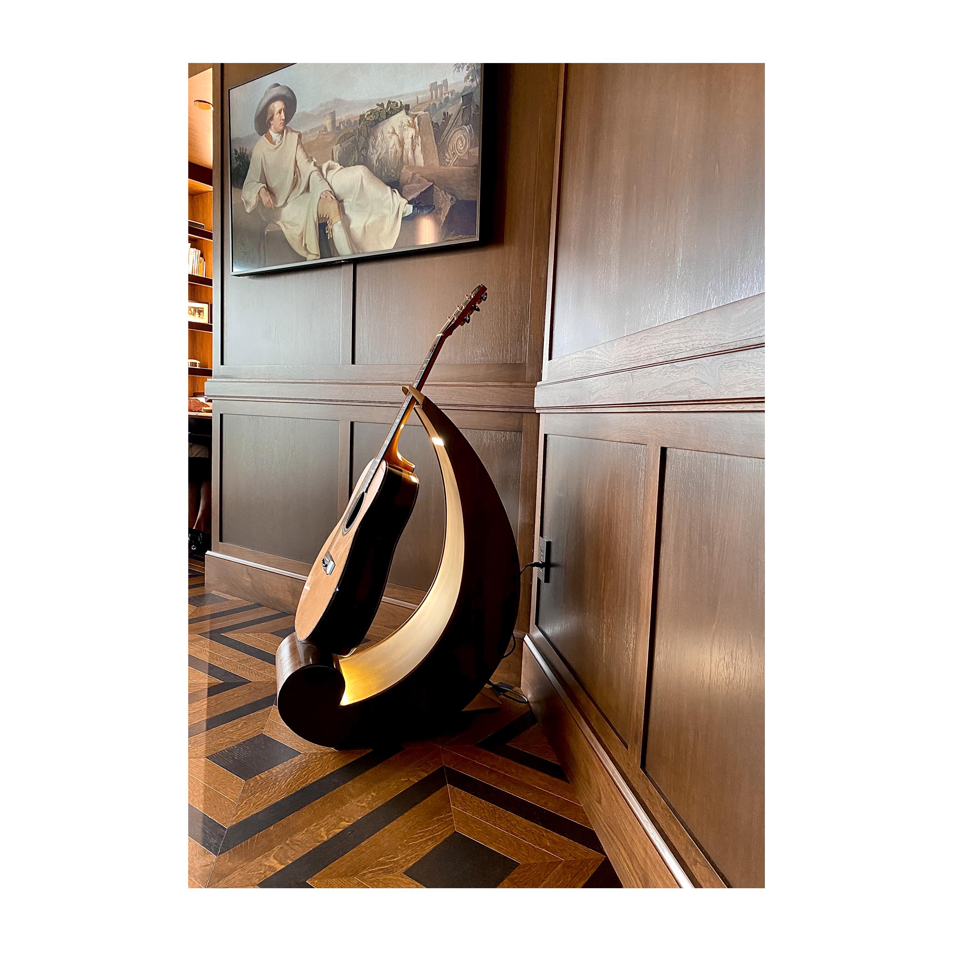 The guitar stand is a stunning piece of functional art that is inspired by the shape of a bass clef note. The stand's sculptural shape is both modern and timeless, and it provides a stable and secure resting place for your guitar. The back support