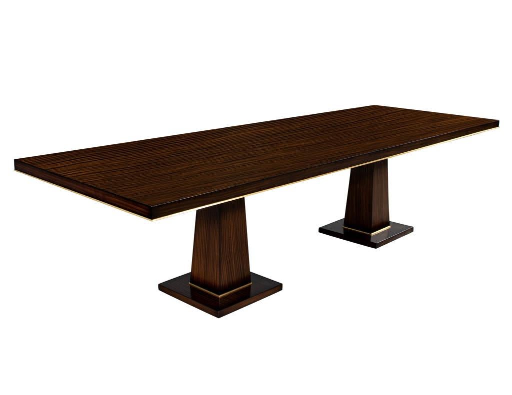 Carrocel Custom Walnut Dining Table with Brass Details. Handcrafted by the artisans at Carrocel in a beautiful rift cut walnut wood. Sleek squared tapered pedestal design with brass details. Completed in a rich dark walnut satin lacquered finish