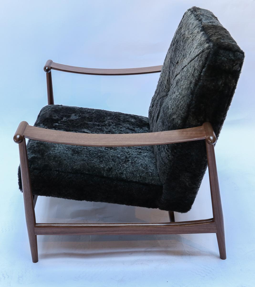 Pair of custom midcentury style armchairs in American Walnut with black snow top sheepskin upholstery and decorative toggle. Made in Los Angeles by Adesso Imports. Can be done in different colors and woods.