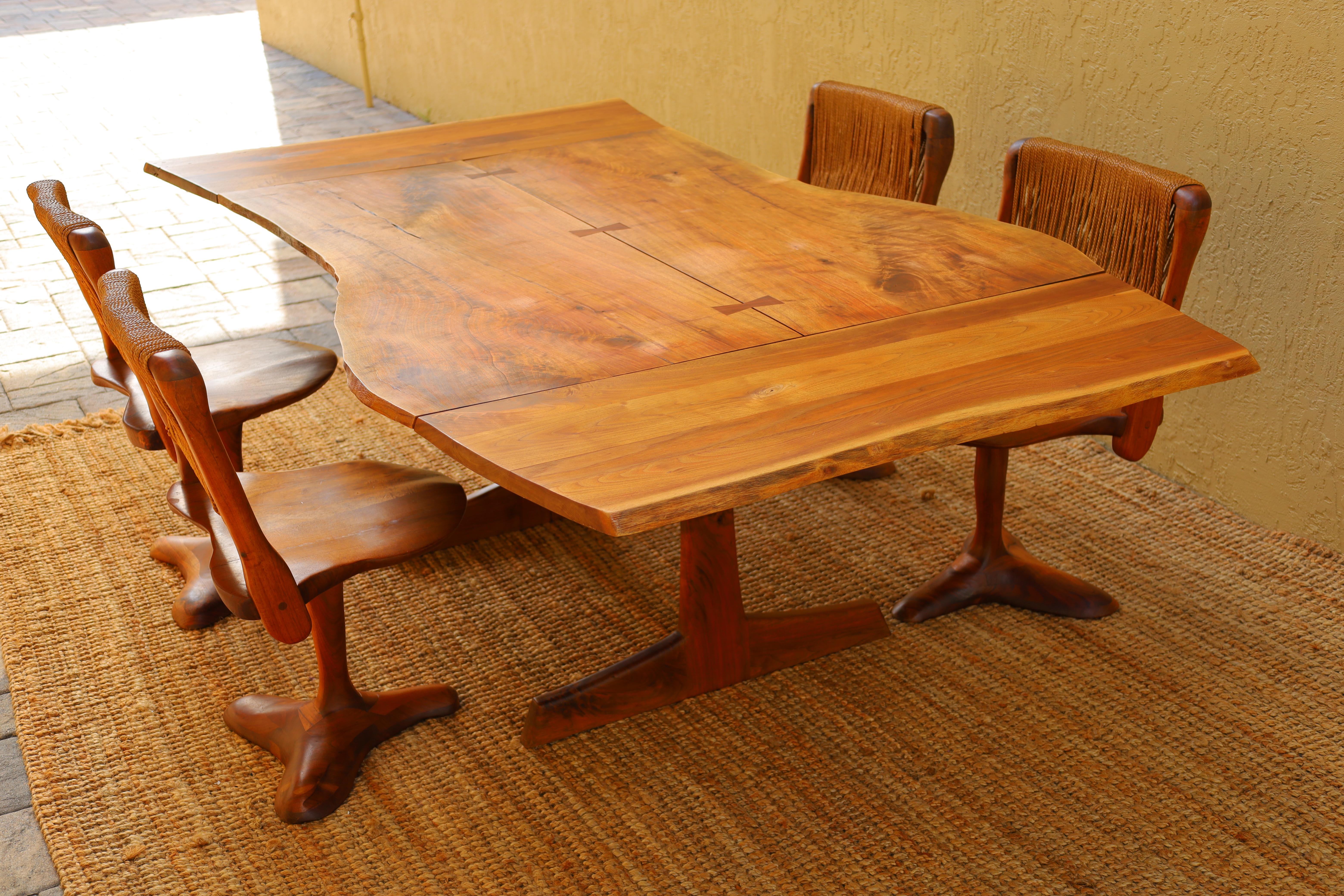 We are proud to offer this exceptional piece of American Studio Craft history by acclaimed woodworker and artist Richard Rothbard. A one-of-a-kind, book-matched walnut slab dining table with a suite of four sculptural walnut + rush chairs. 

In