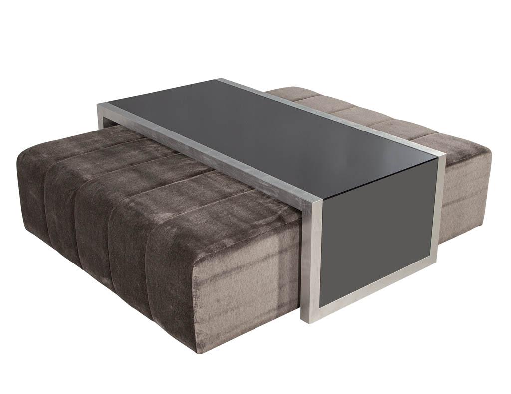 Custom waterfall coffee table with pullout ottomans. Featuring smoked mirror inserts with silver leaf frame. Complimented with two large oversized ottomans on pullout wheels. This set is hand crafted and made to order. Lead times are 10-14