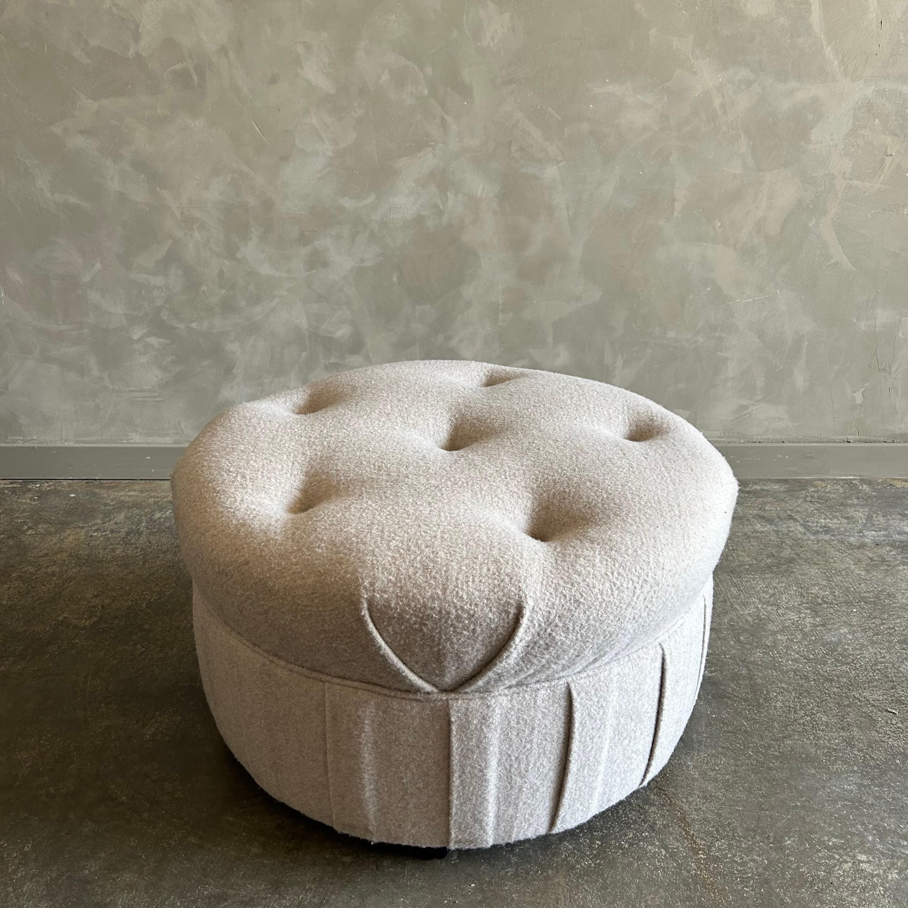 Custom Upholstered Round tufted ottoman
Size 32” rd. X 18”h
Upholstered in a natural oat wool, with hand tufting, and a box pleated apron.
This ottoman works well in a dressing room, and has rollers on the bottom.
The rollers can be removed.
Can be