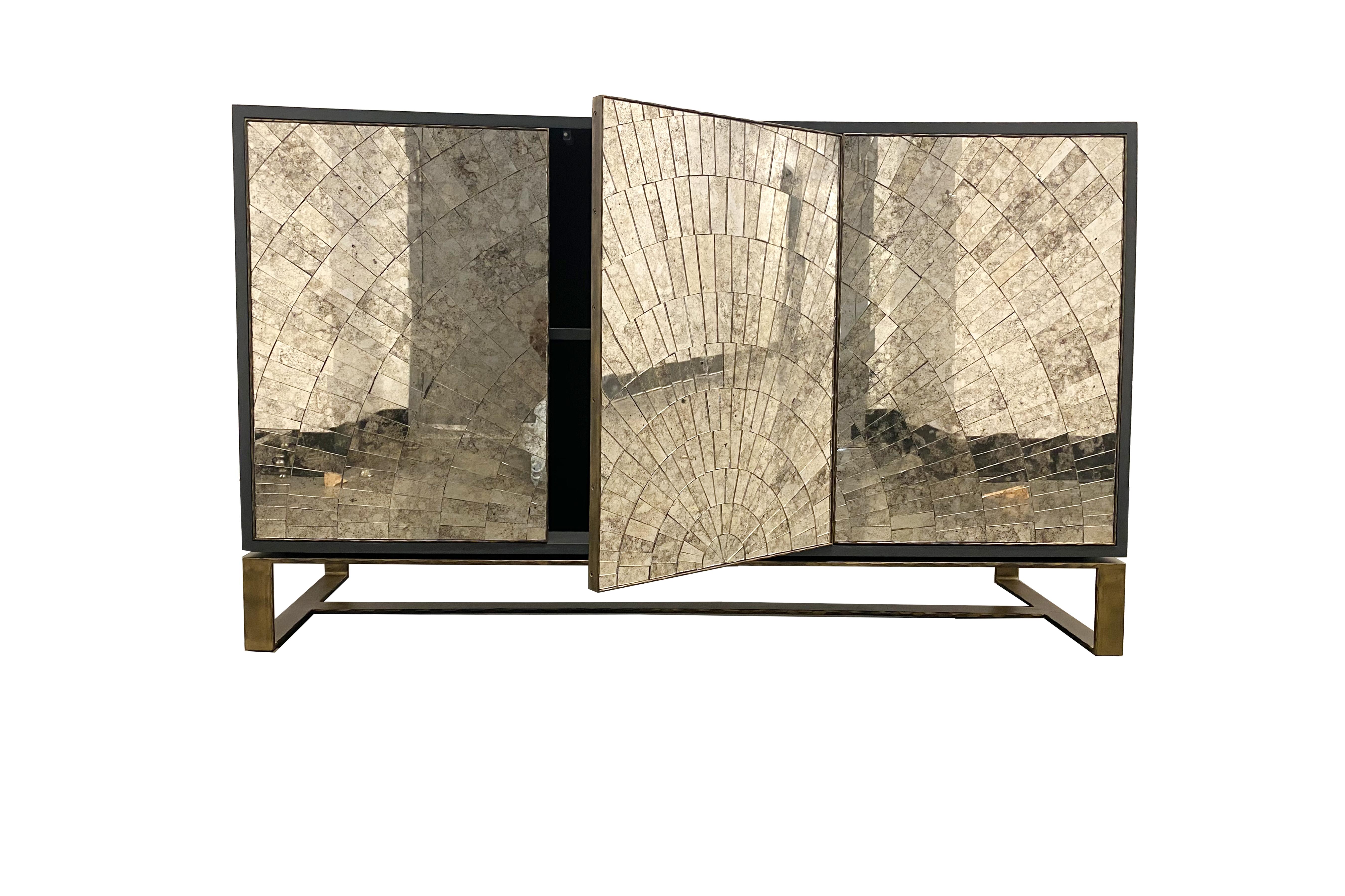 Das verspiegelte Buffet mit Sonnenschliff von Ercole Home hat eine 3-türige Front mit 2 Innenfächern und ist aus dunkelgrau lackiertem Holz. Handgeschliffene Glasmosaike in antikem Spiegelsilber schmücken die Oberfläche in einem strahlenförmigen