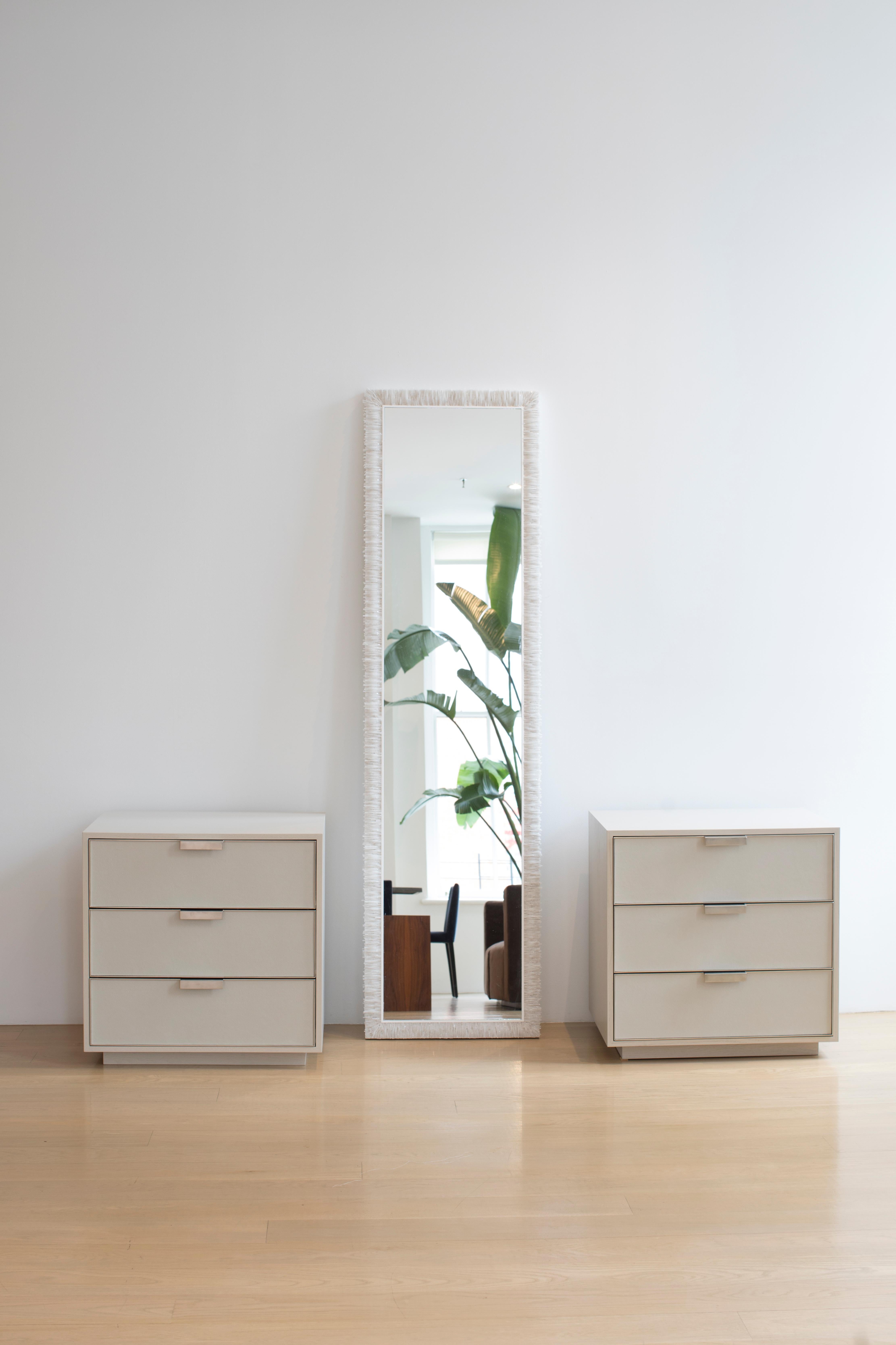 This platform nightstand by Ercole home has a 3 drawer front , with a custom dark champagne glossy finish on Oak.
Each drawer is covered in a faux shagreen leather face, outlined in a delicate brushed nickel metal frame. Custom sizes and finishes