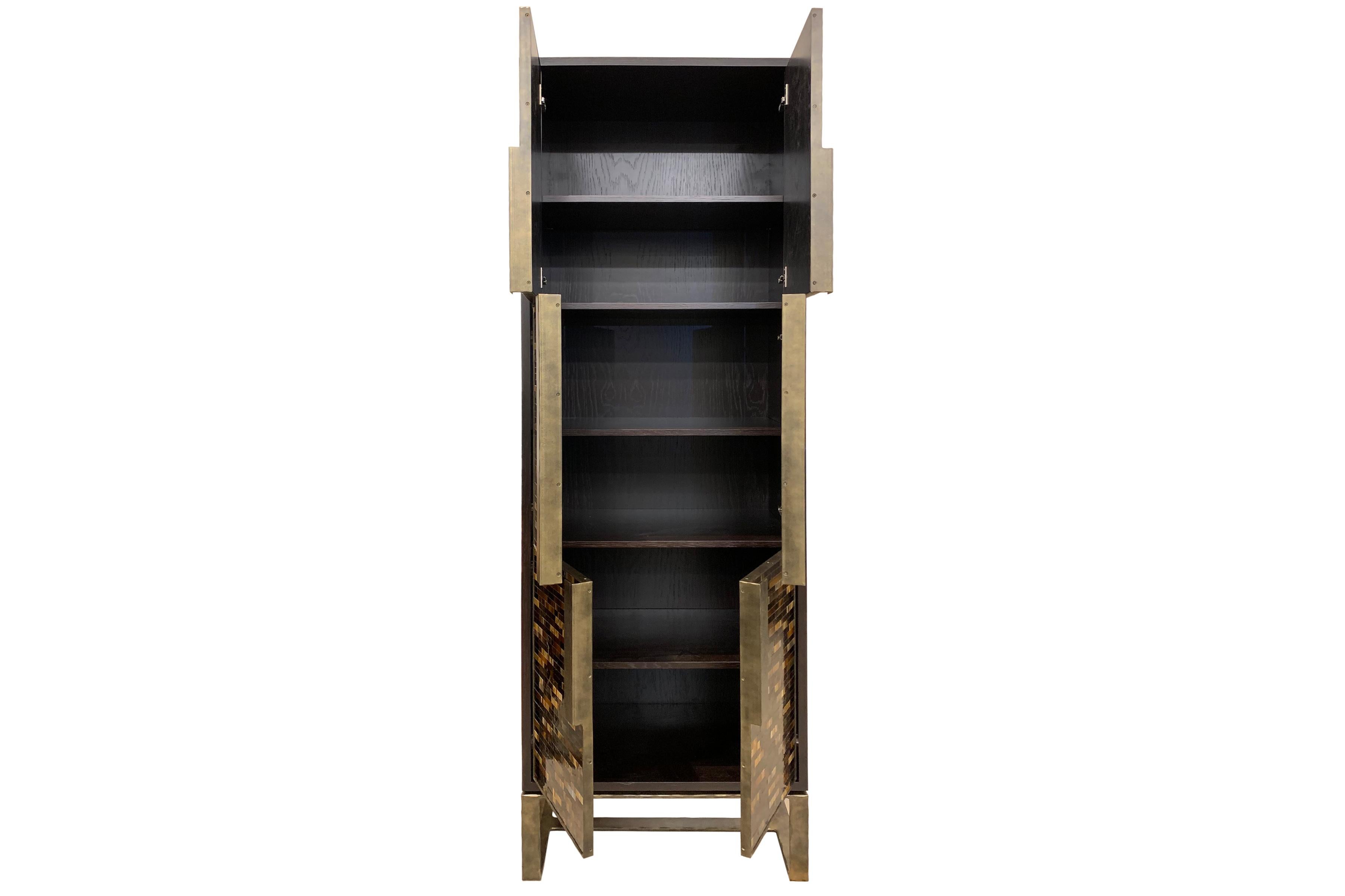 The Chelsea bar cabinet by Ercole Home has a 6-door front, with Espresso wood finish on oak.
Handcut glass mosaics in dark and medium chocolate decorate the surface in Luis pattern.
Hand-hammered metal framed doors, handles, and base in bronze