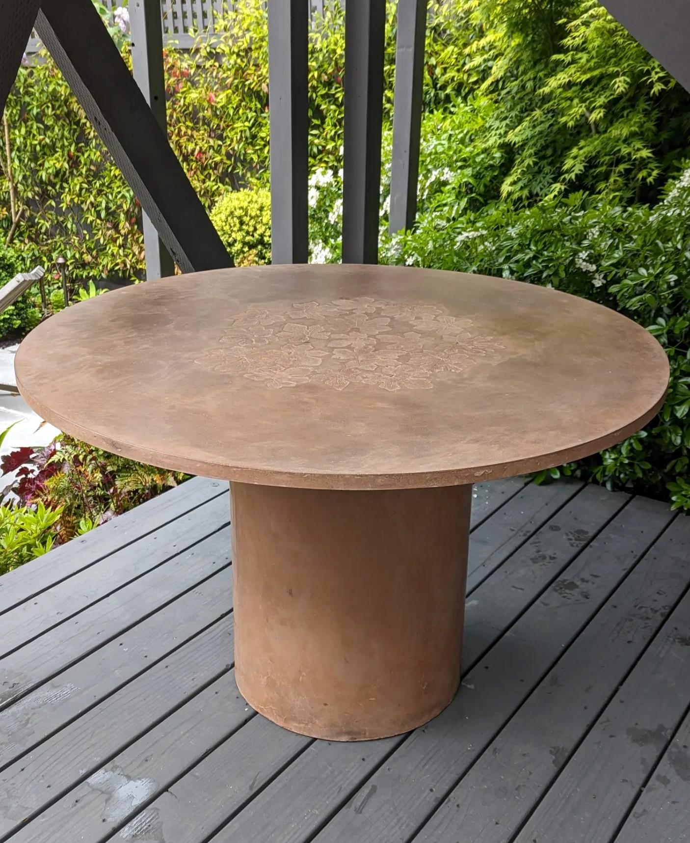 Highly customizable mid-weight round concrete dining or coffee table tops on pillar bases, with or without impressions from real leaves, can make a natural addition to nearly any room or outdoor environment. Tops are secured to bases with velcro.