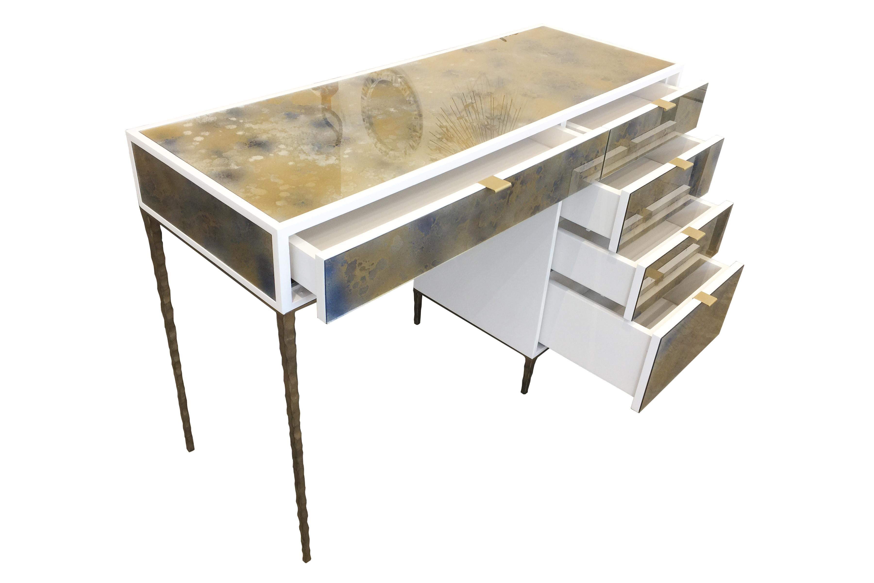 The Mystic Byzantine gold vanity by Ercole Home has a 5-drawer, with ivory wood finish on oak. Hand painted eglomise glass panels are inset on the surface.
There are five aluminum pulls in brushed brass finish.
The hand hammered metal base is in