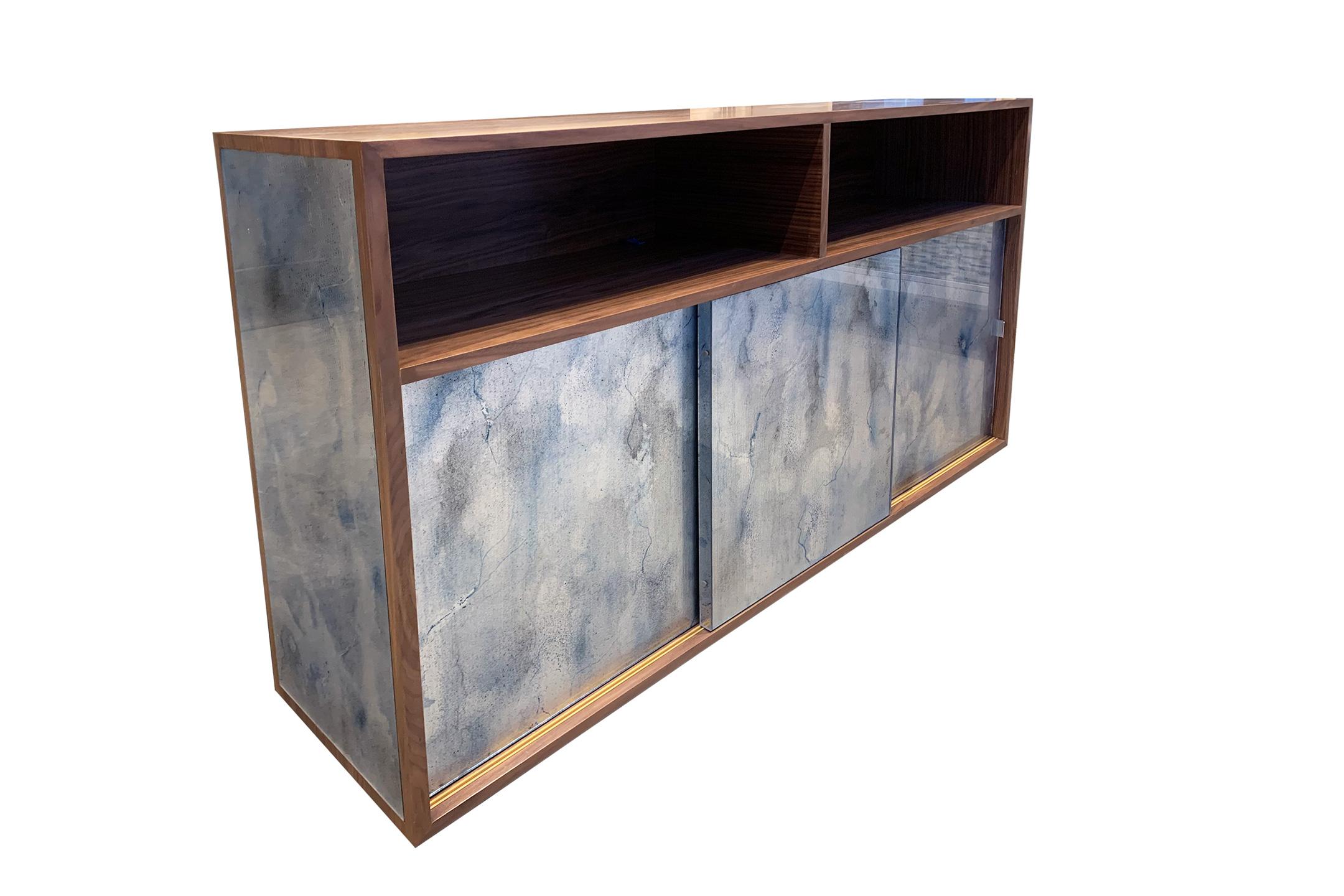 The Mystic buffet or credenza by Ercole Home has a 3-sliding door front, with natural wood finish on walnut.
Hand painted glass panels in Midnight Moon are on the door and side surface.
The platform base with 2'' toe kick in the same finish as the