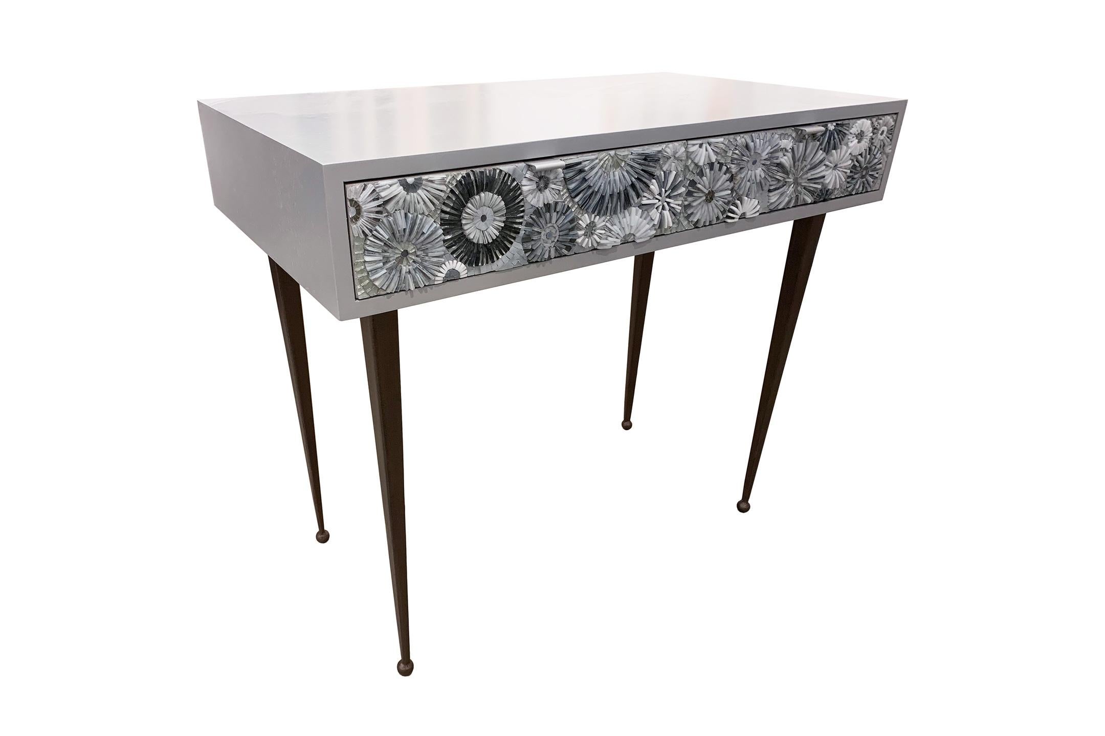 The Pavia Blossom desk/vanity by Ercole Home has a 2-drawer, with a sky gray wood finish on oak.
Handcut glass mosaics in bluegreen and turquoise decorate the drawer fronts in blossom (3-Dimensional flowers) pattern.
There are two aluminium pulls