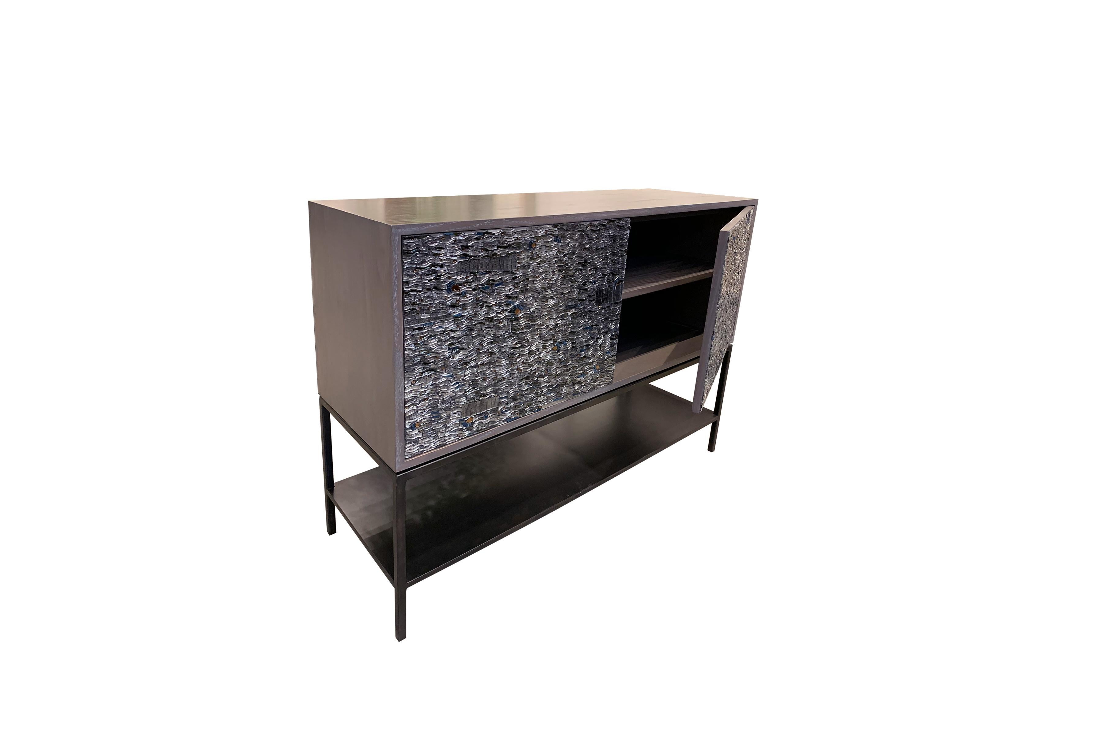 The Ravenna cabinet by Ercole Home has a 2-door front, with metal base in natural steel finish. The metal shelf is 5” H off the floor.
Handcut glass mosaic in grey mirror, pewter, antique pewter, silver, antique silver, fume, notte and bronze