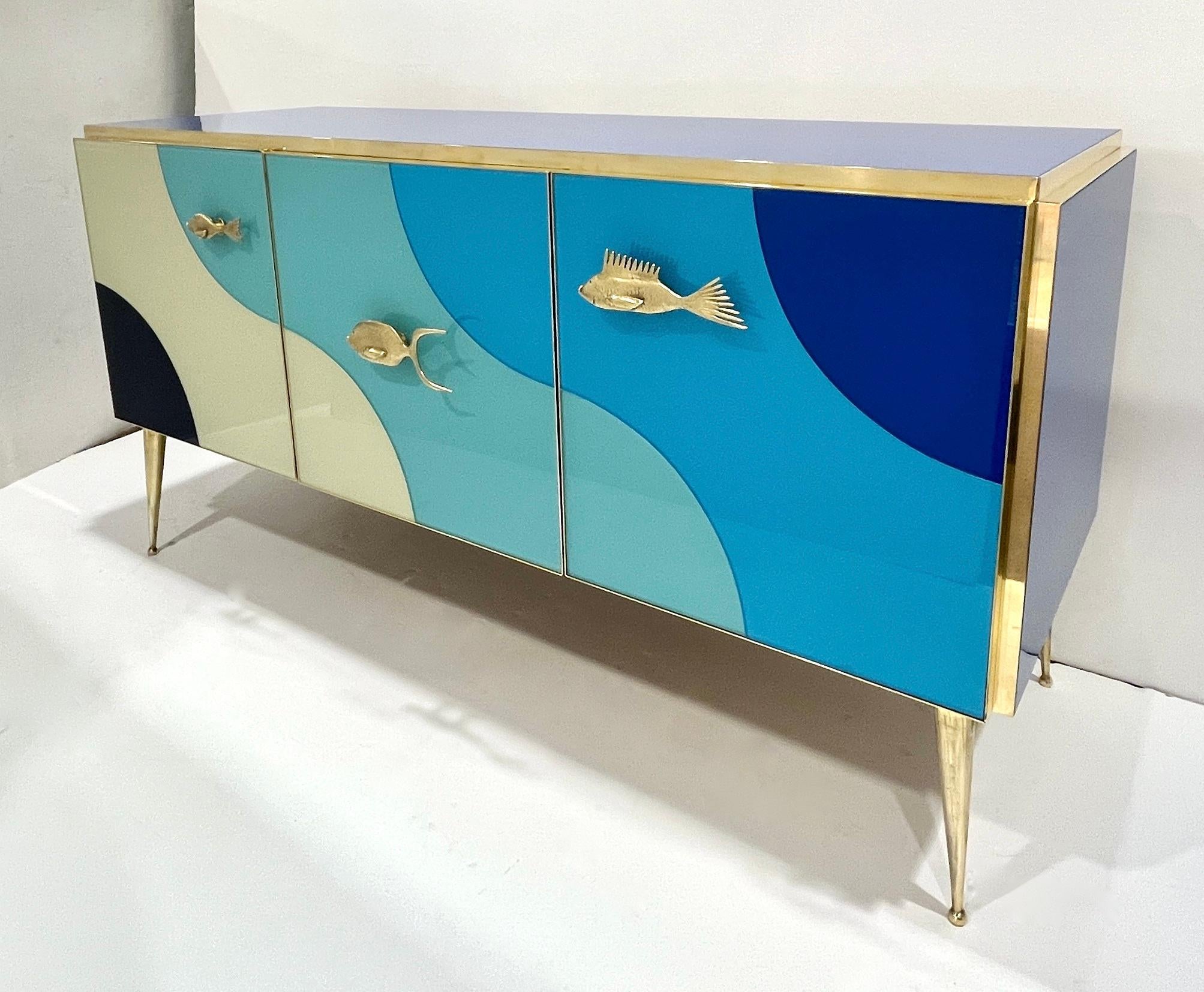 Armario moderno de 3 puertas hecho a mano con elegancia inspirada en el mar. Este exquisito aparador personalizable está fabricado totalmente a mano en Italia, con un llamativo motivo marinero. Las tres puertas del armario presentan vibrantes ondas