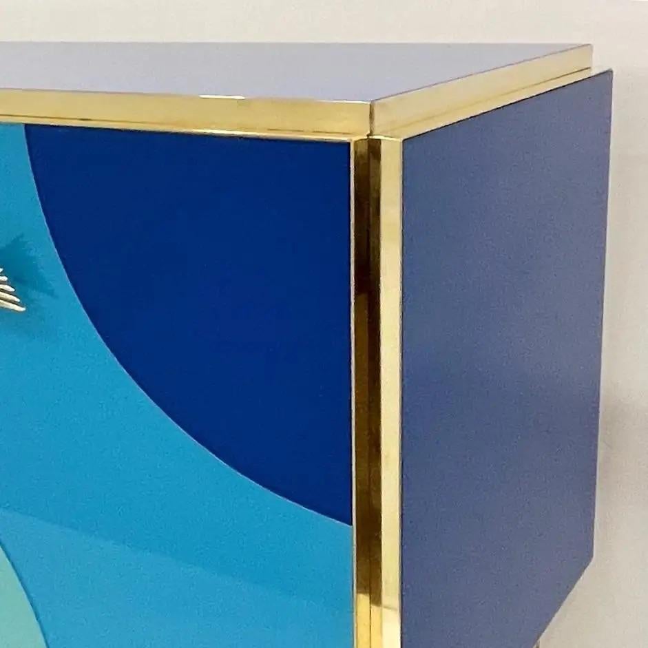 Armario moderno de 3 puertas hecho a mano con elegancia inspirada en el mar. Este exquisito aparador personalizable está fabricado totalmente a mano en Italia, con un llamativo motivo marinero. Las tres puertas del armario presentan vibrantes ondas