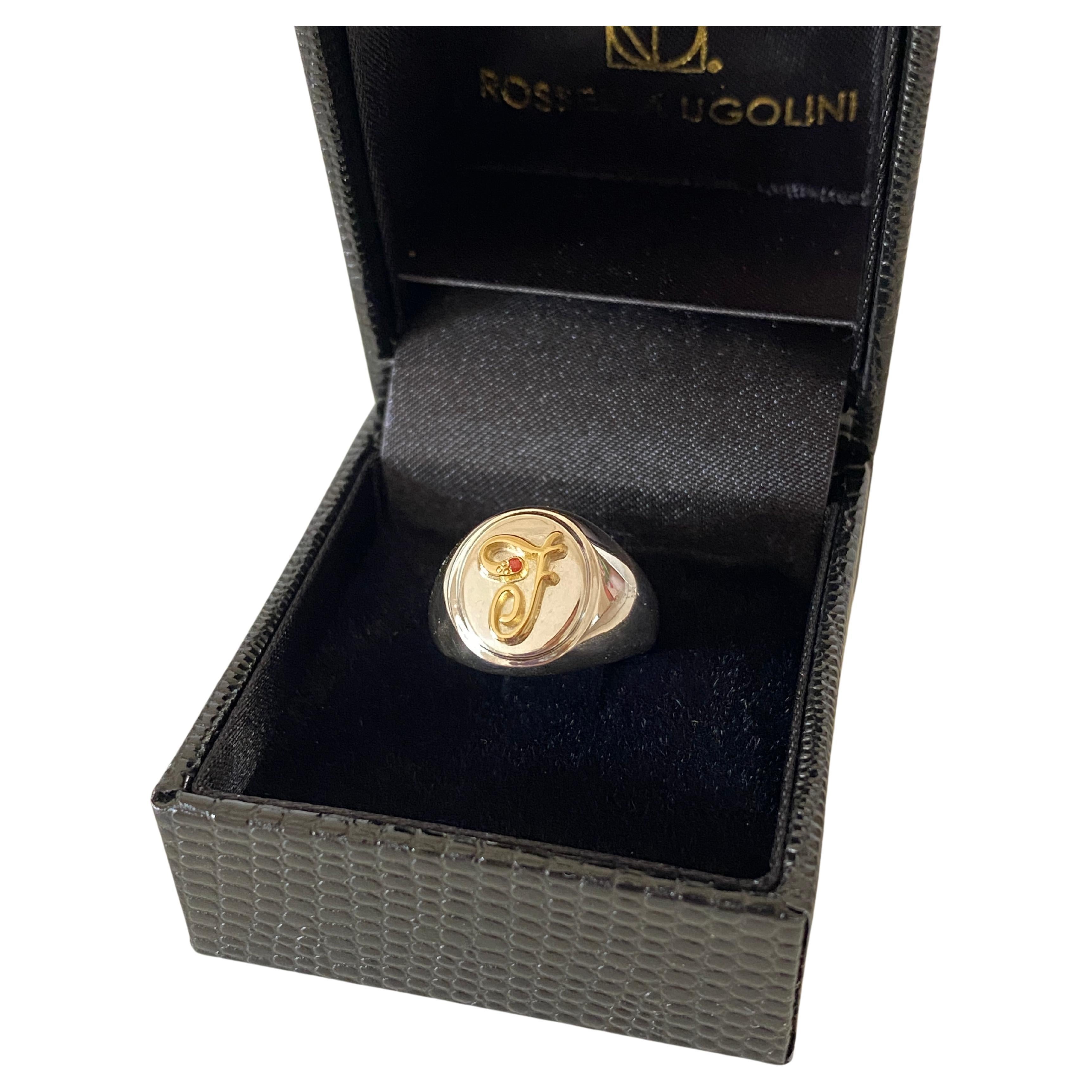 Voici la bague à lettres personnalisable, une création de Rossella Ugolini.  
Méticuleusement réalisée en argent sterling blanc avec une lettre F faite à la main en or jaune 18 carats, cette bague incarne un harmonieux mélange d'élégance et de