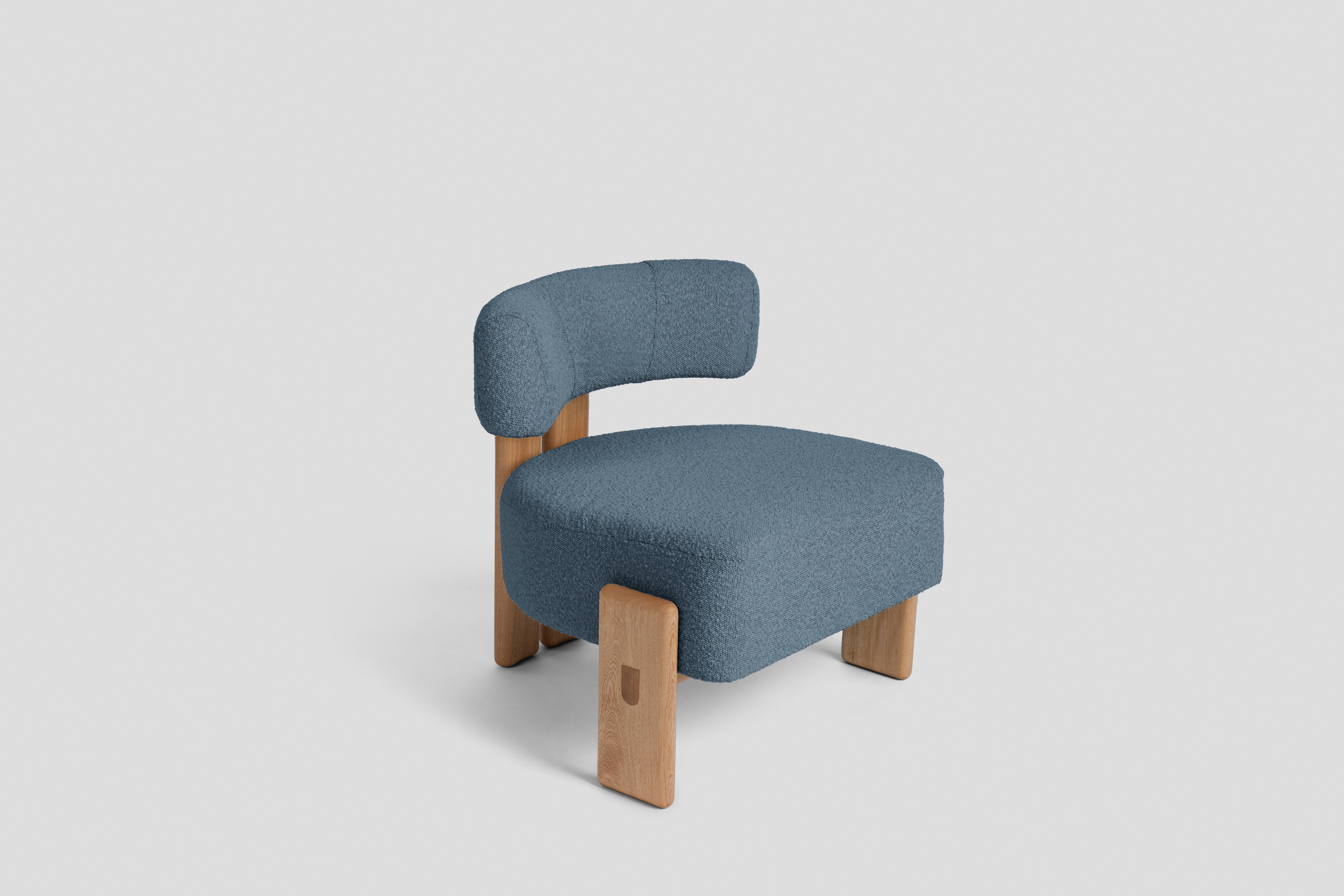 Inspiriert von dreibeinigen Stühlen, hat dieser niedrige Stuhl ein Rückenbein, das aus zwei Teilen besteht, die durch ein rundes Holzdetail verbunden sind, und zwei Seitenbeine, die die Sitzfläche umschließen. Er ist als Ergänzung in einem