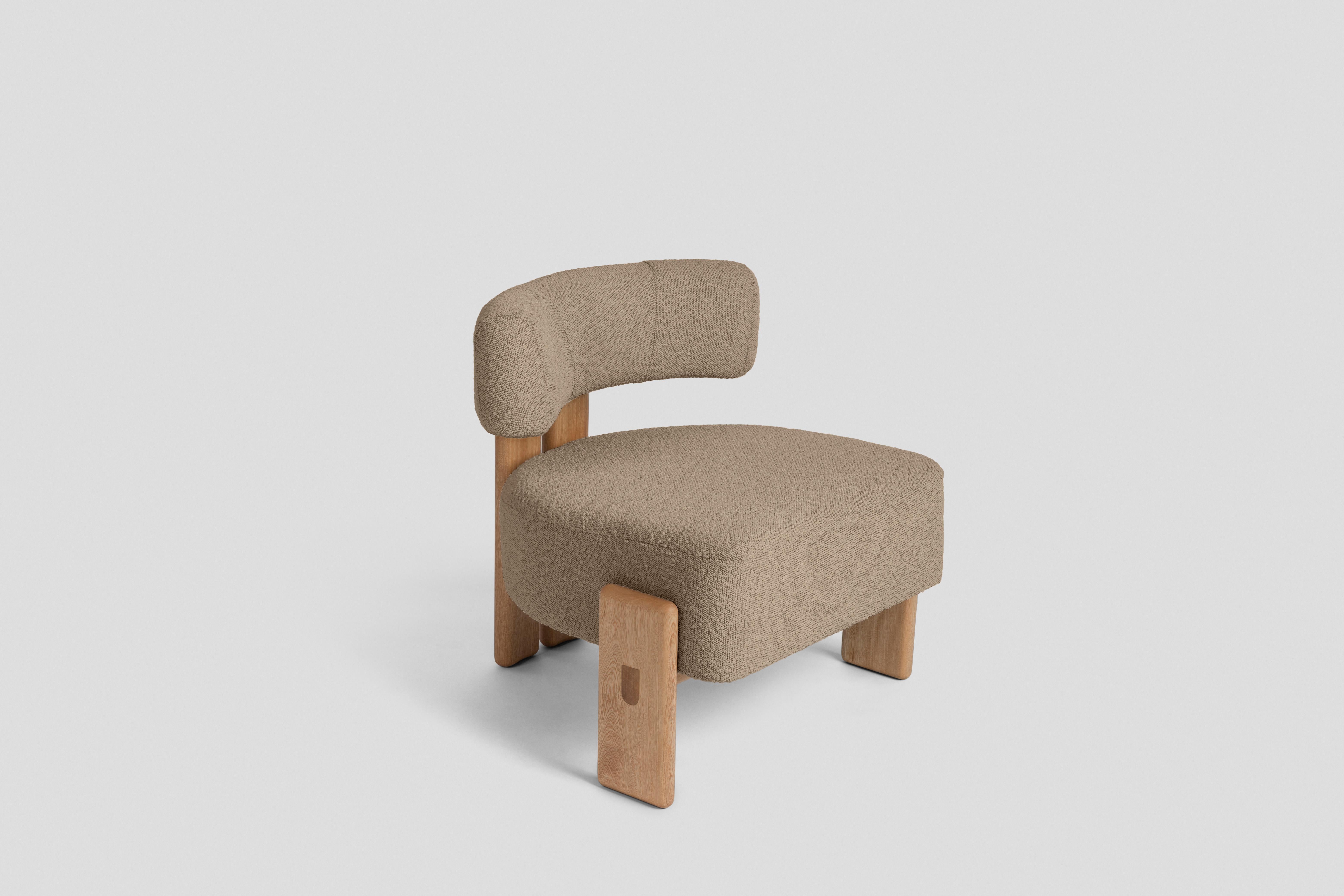 Ispirata alle sedie a tre gambe, questa poltroncina ha una gamba posteriore formata da due pezzi uniti da un dettaglio circolare in legno e due gambe laterali che abbracciano la seduta. È pensata come complemento in un soggiorno o come sedia