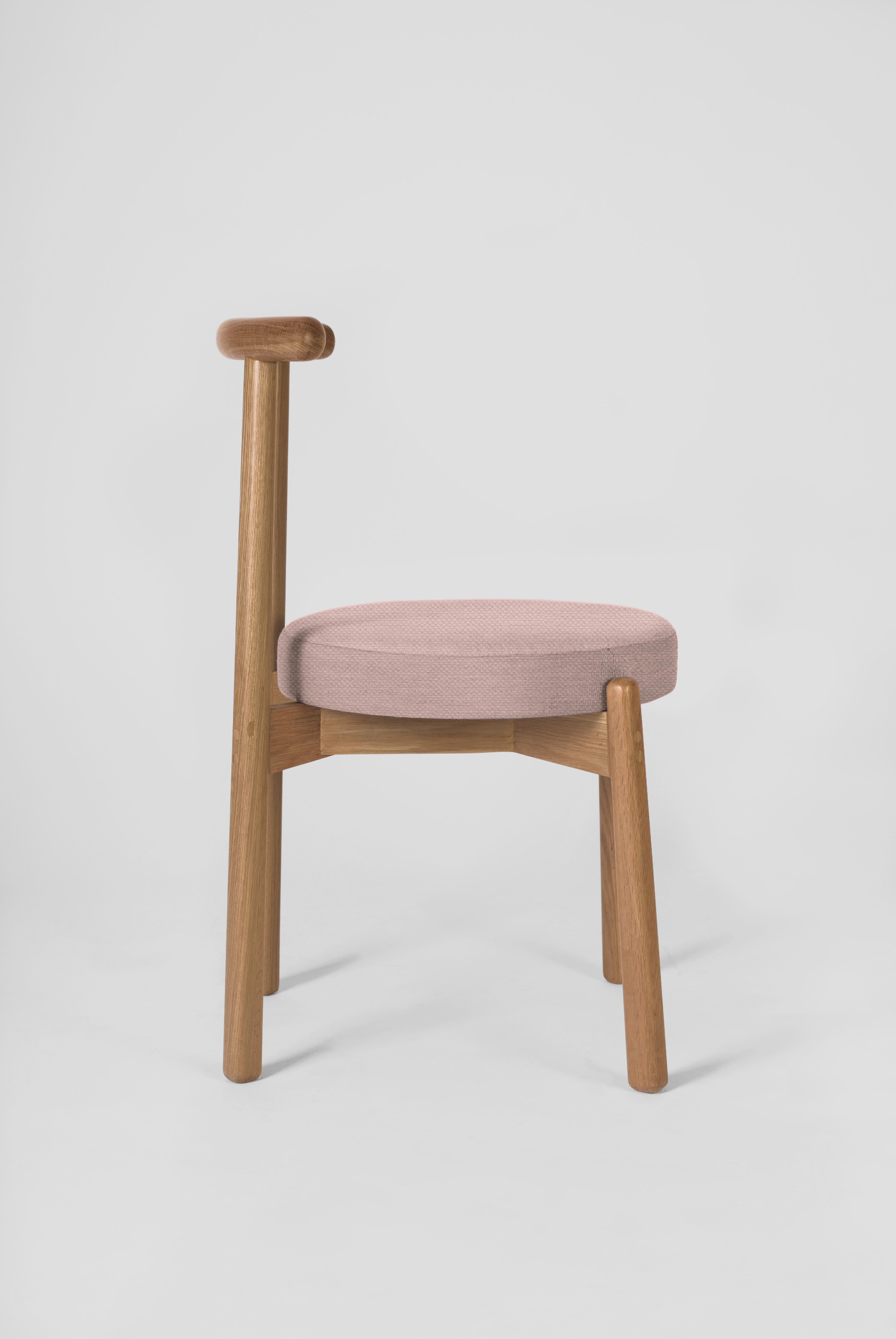 Die Schlichtheit dieses Designs macht diesen Stuhl zu einem vielseitigen Möbelstück, das zu verschiedenen Esstischen und Räumen passt. Die Struktur ist aus massivem Eichenholz gefertigt. Die Kissenbezüge können auf Anfrage gemäß den Katalogoptionen