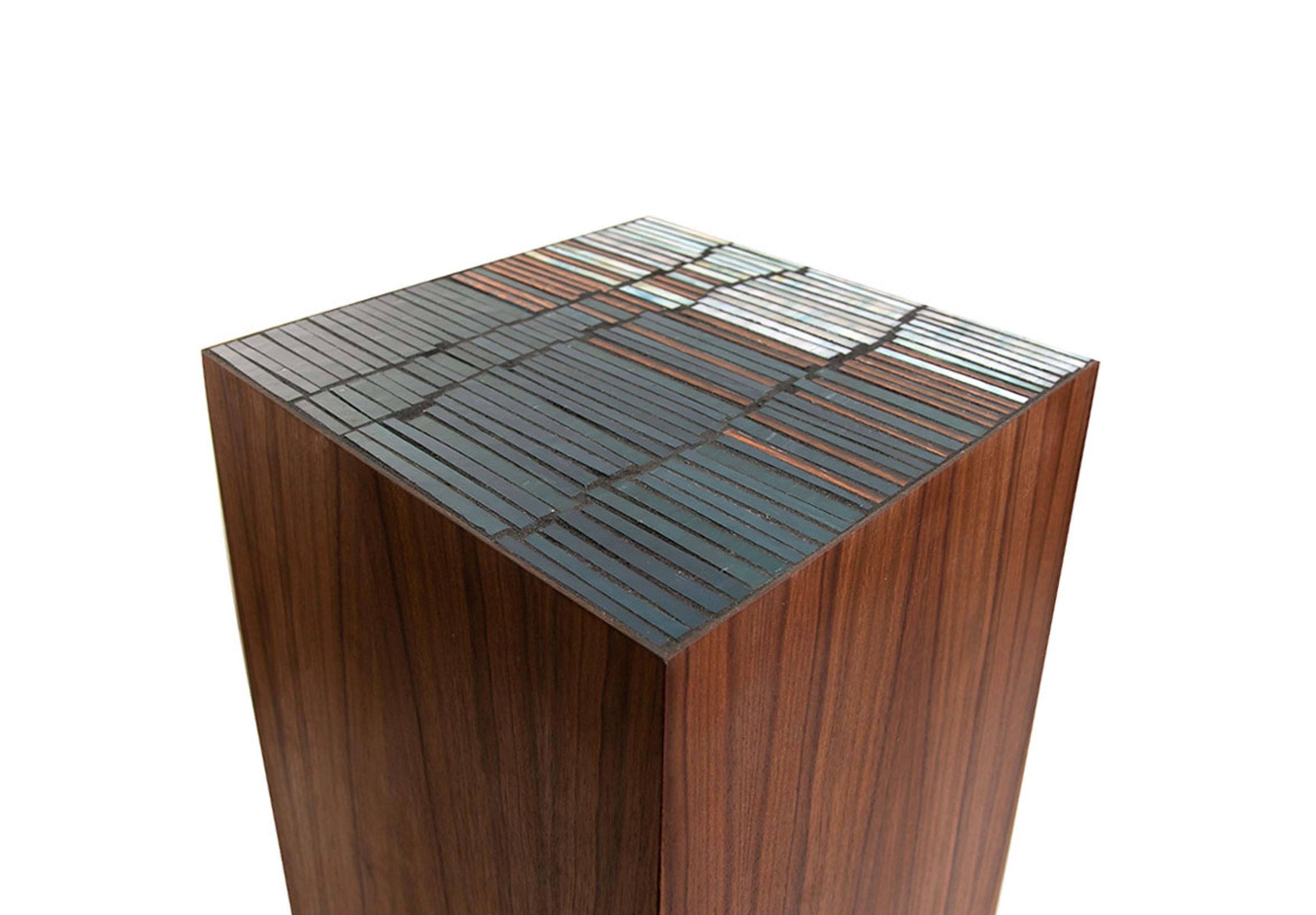 The Natura Pedestal by Ercole Home has a natural wood finish on Walnut. Handcut glass mosaics in Teal, Blue, Copper glass mosaic decorate the top surface in Fragments pattern. 
Custom sizes and finishes are available. 
Made in New York