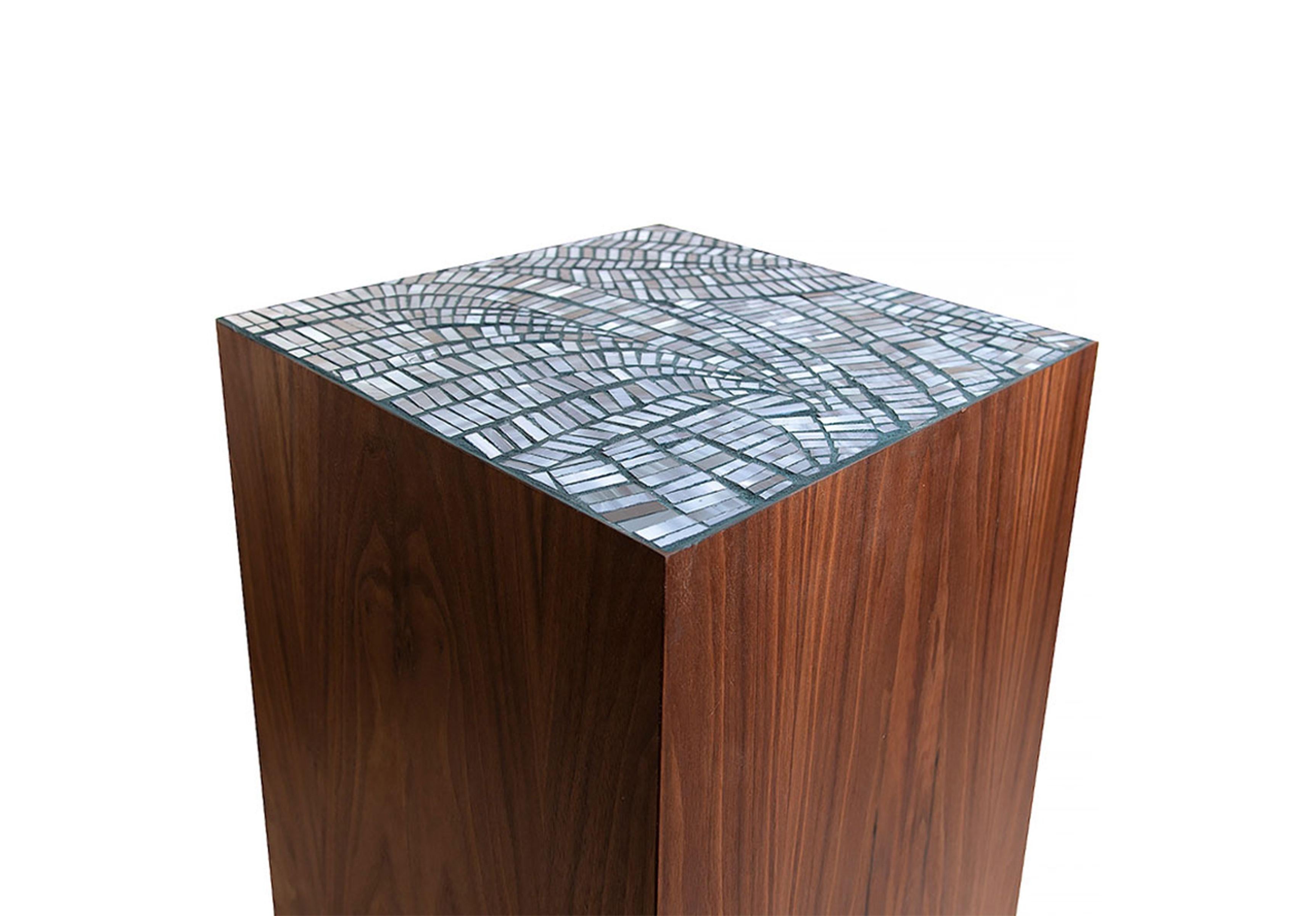 The Natura Pedestal by Ercole Home has a natural wood finish on Walnut. Handcut glass mosaics in Light Cloudy Notte glass mosaic decorate the top surface in Plume pattern. 
Custom sizes and finishes are available. 
Made in New York City.

#pedestal
