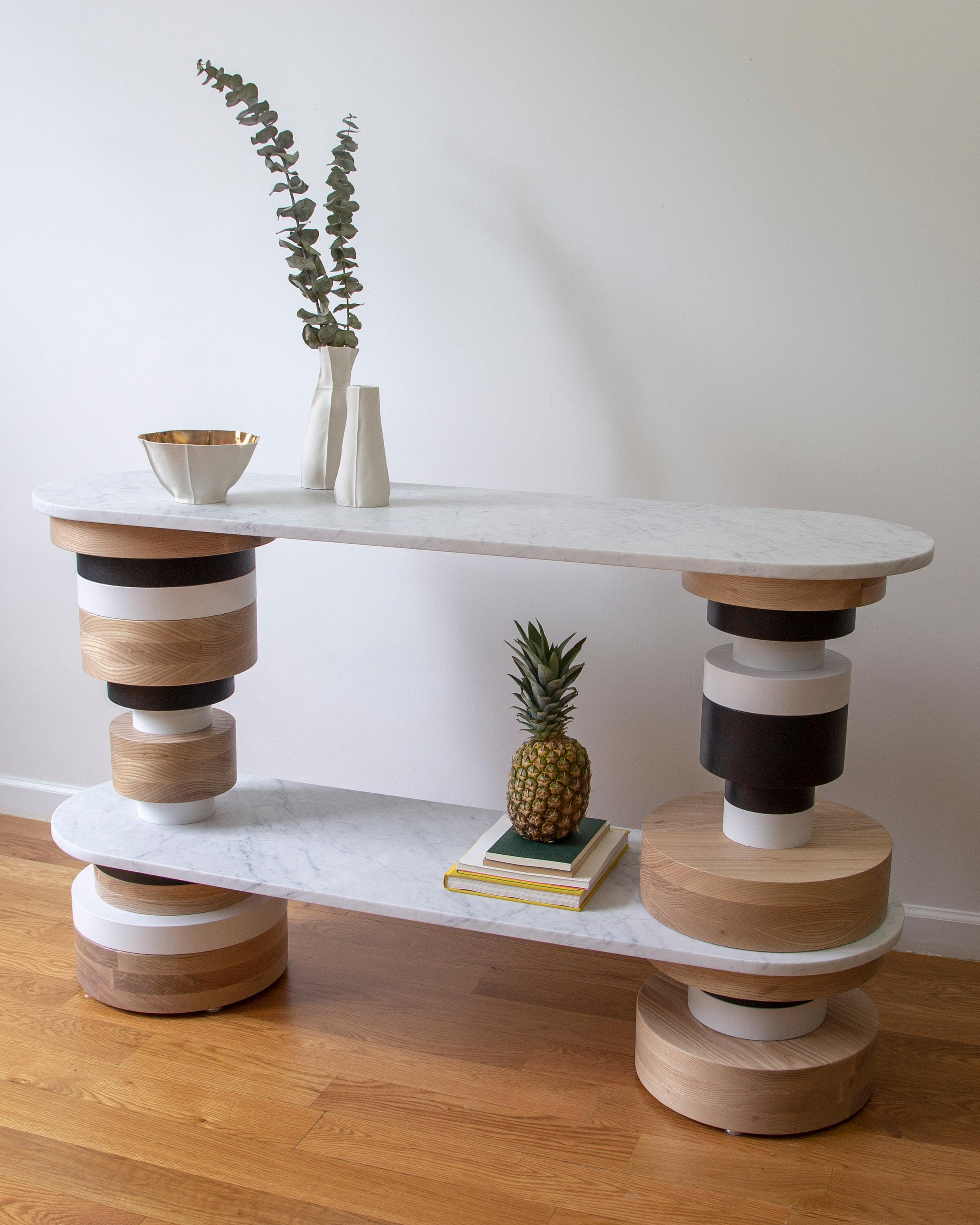 The Sottsass-inspired “Sass Console Table” is a bold, graphic statement piece. A honed Carrara marble top sits on an Amish-made base composed of painted and stacked wood circles. Made to order.

The version as shown is 32.5
