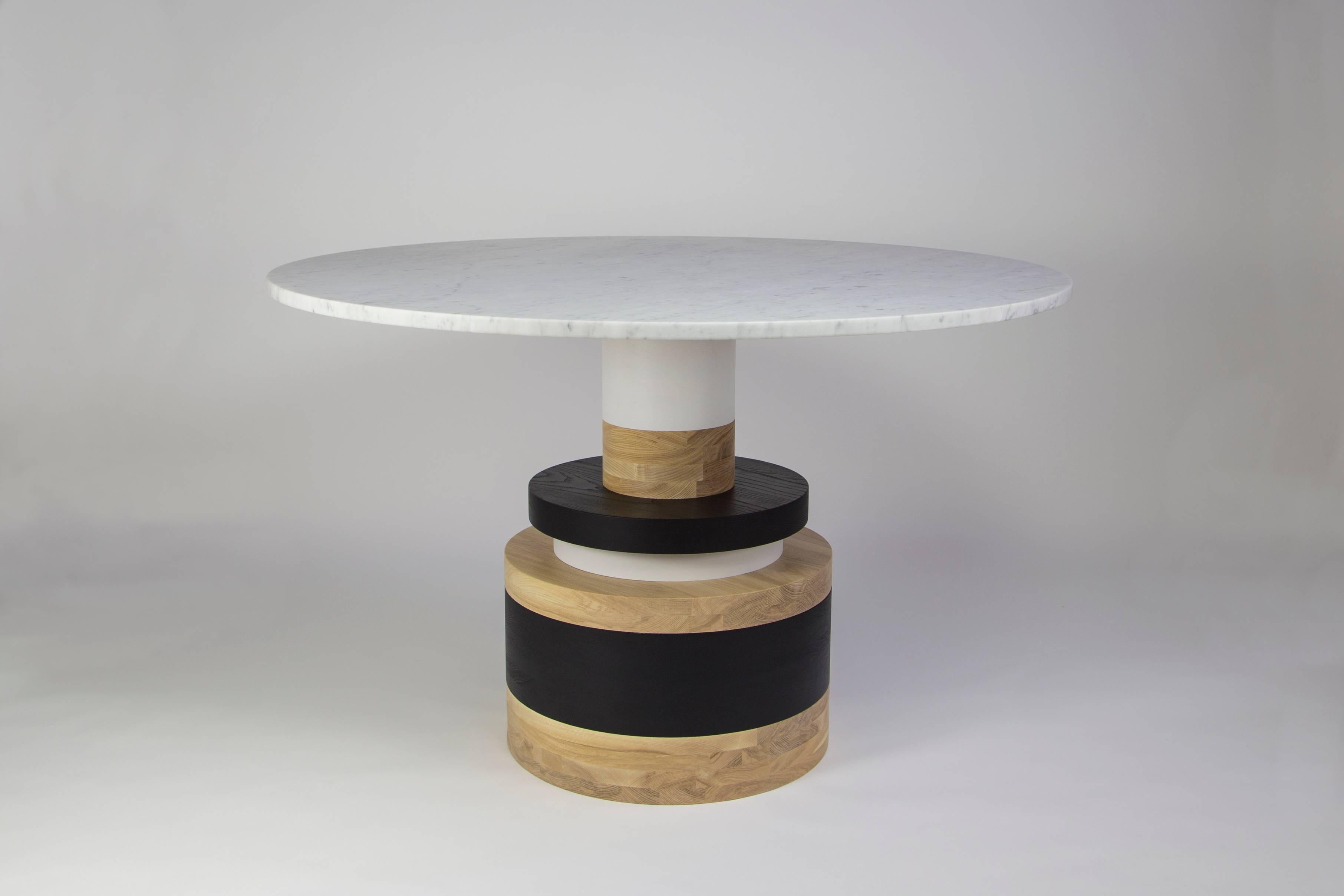 The Sottsass-inspired “Sass Dining Table” is a bold, graphic statement piece. A honed Carrara marble top sits on an Amish-made base composed of painted and stacked wood circles. 

The version as shown is 47