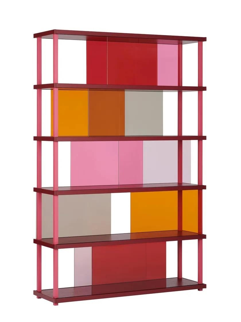 Le linee nette e i rettangoli colorati della libreria CORES ricordano i dipinti di Piet Mondrian. Nella versione progettata per essere posizionata contro una parete, gli inserti in vetro scorrevoli sui frontali delle mensole creano accenti di colore