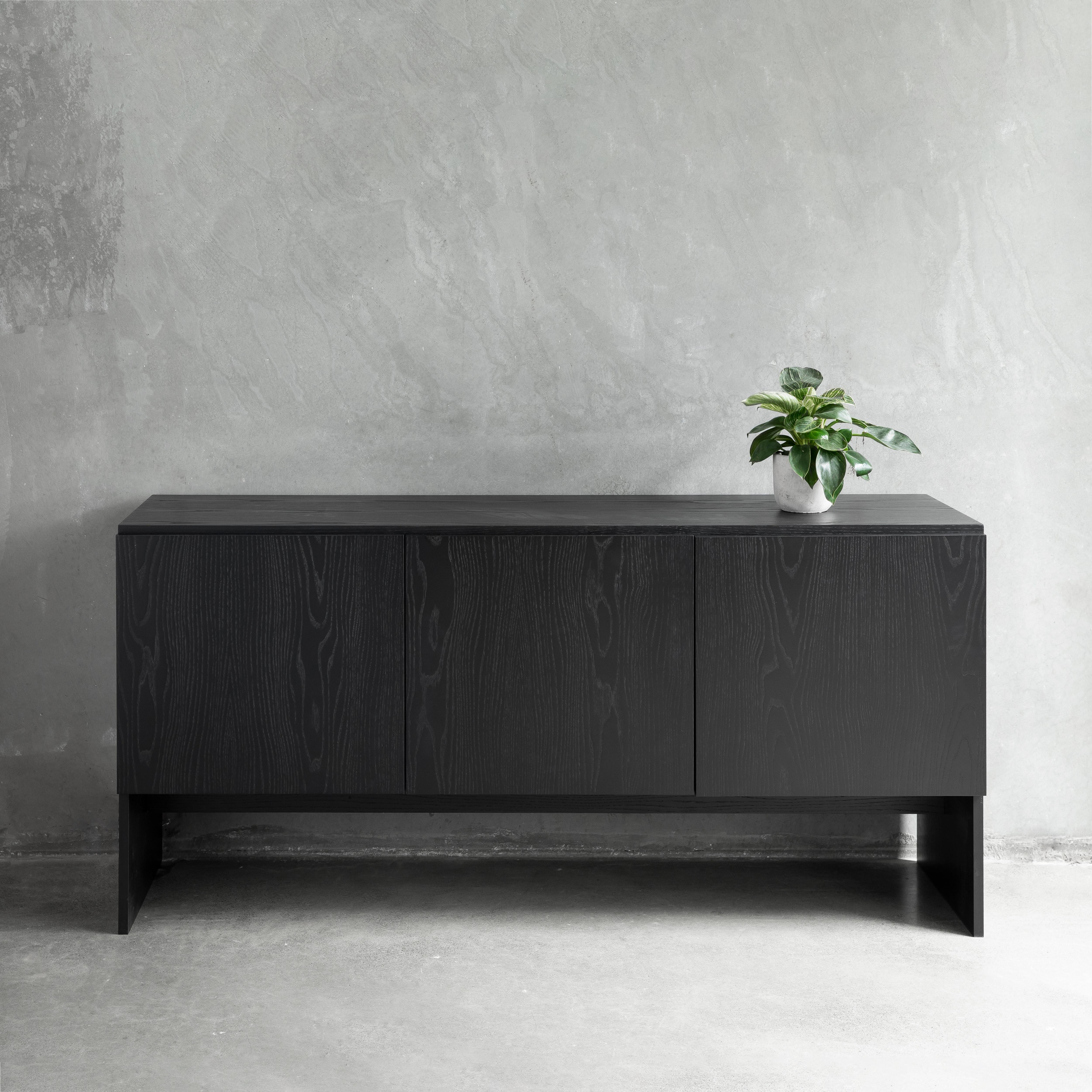De diseño sencillo pero presencia sofisticada, la Credenza Slab es una moderna solución de almacenamiento adecuada para hogares y espacios de oficina.

El perfil geométrico del aparador combina líneas y ángulos limpios, acentuados por la