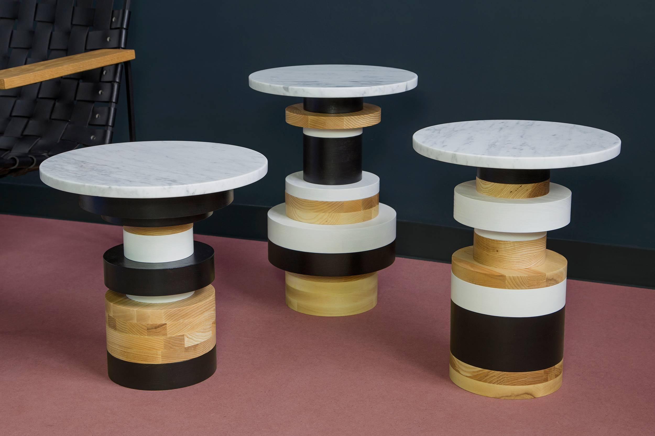 The Sottsass-inspired “Sass Tables” are simple, sculptural accents for any interior space. Made from stacked wooden bases and a honed marble-top, Sass tables are perfect individually or clustered. Measure: 20 inches tall with 14 inch marble top.