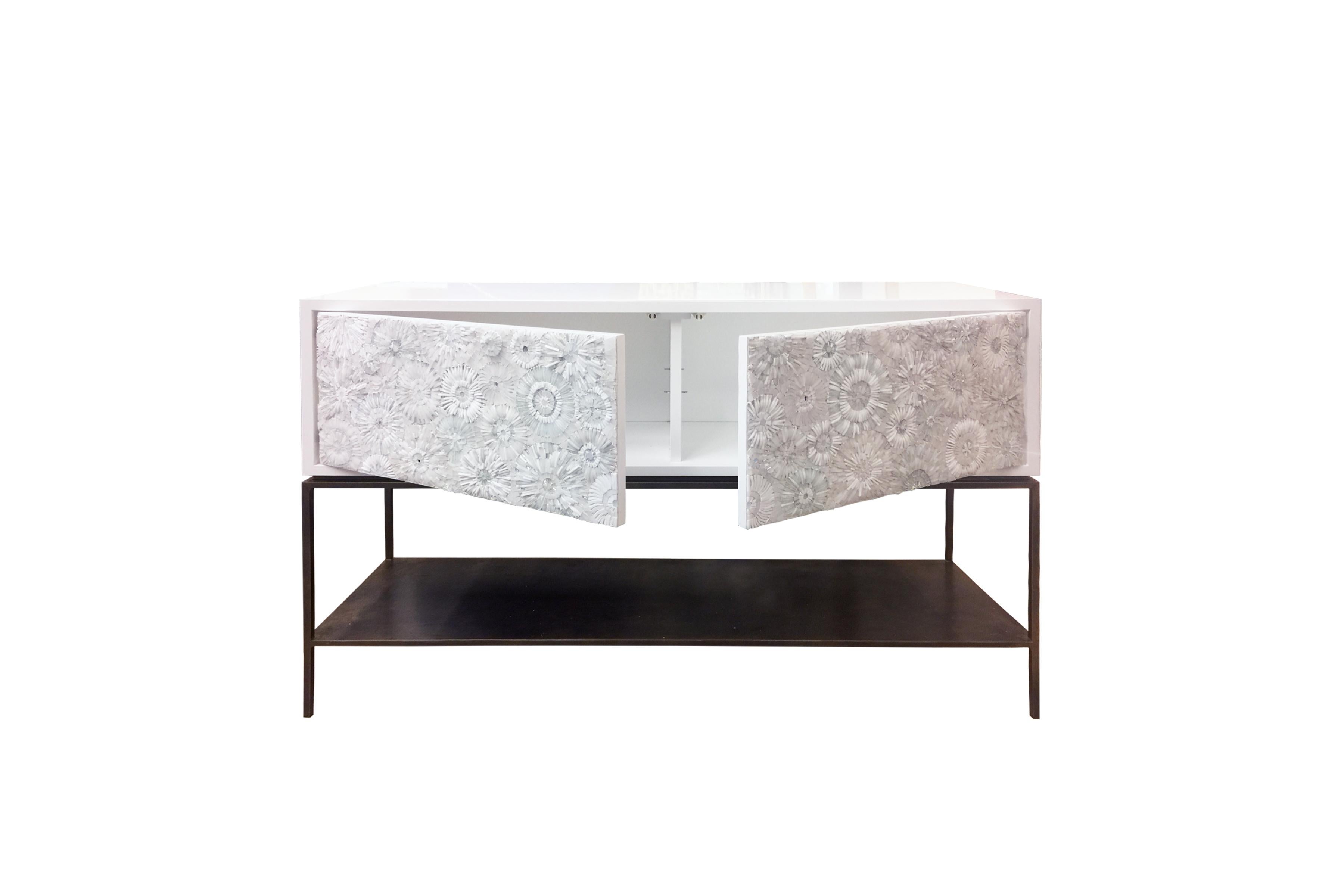 The Blossom serving buffet by Ercole Home has a 2-door front, with metal base in bronze finish. The metal shelf is 5” H off the floor.
Handcut glass mosaic in variety shades of white and ivory decorate the surface in Blossom mosaic pattern.
White