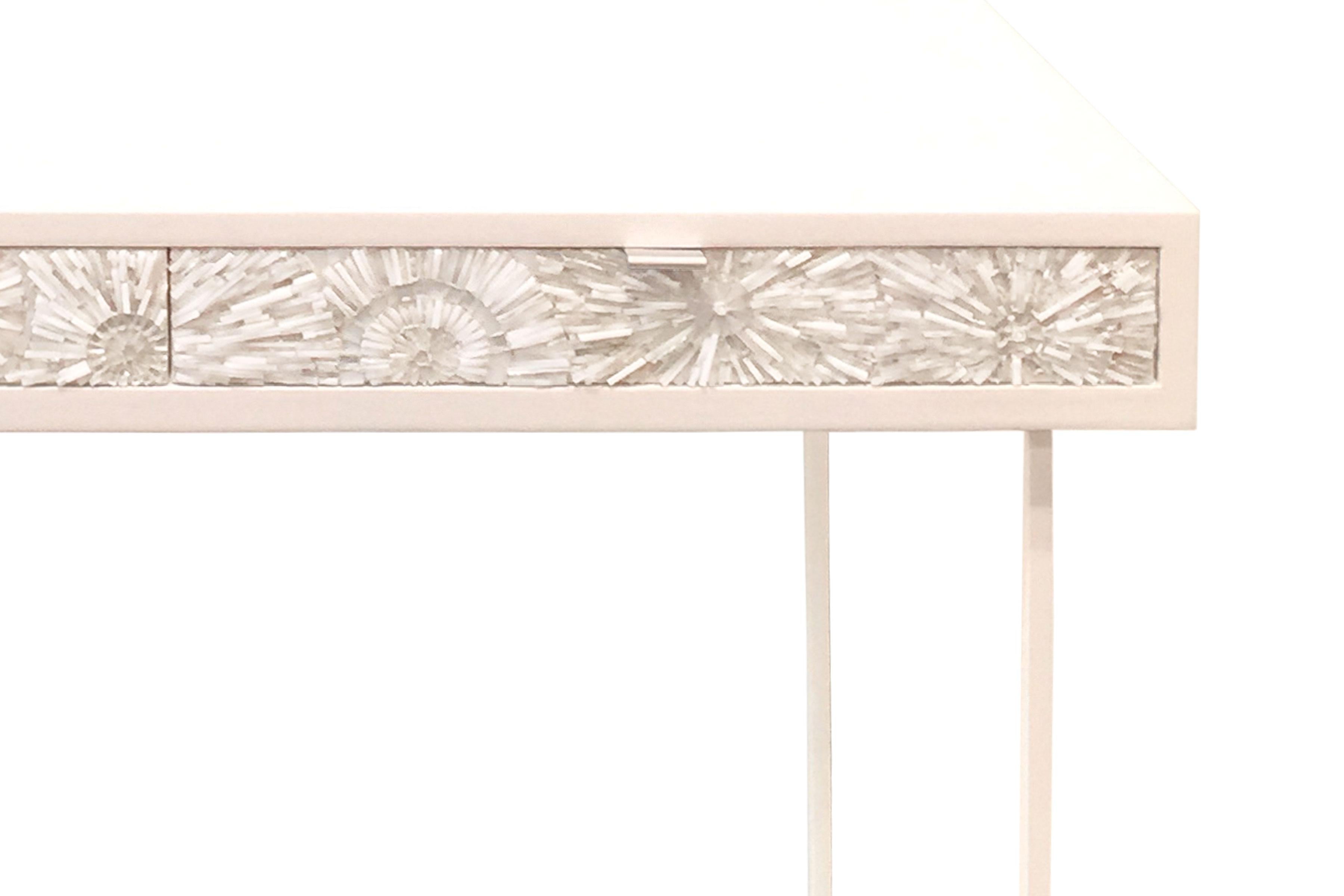 The Pavia Blossom desk/vanity by Ercole Home has a 2-drawer, with a painted white wood finish on oak.
Handcut glass mosaics in white and silver decorate the drawer fronts in blossom (3-dimensional flowers) pattern.
There are two aluminium pulls in