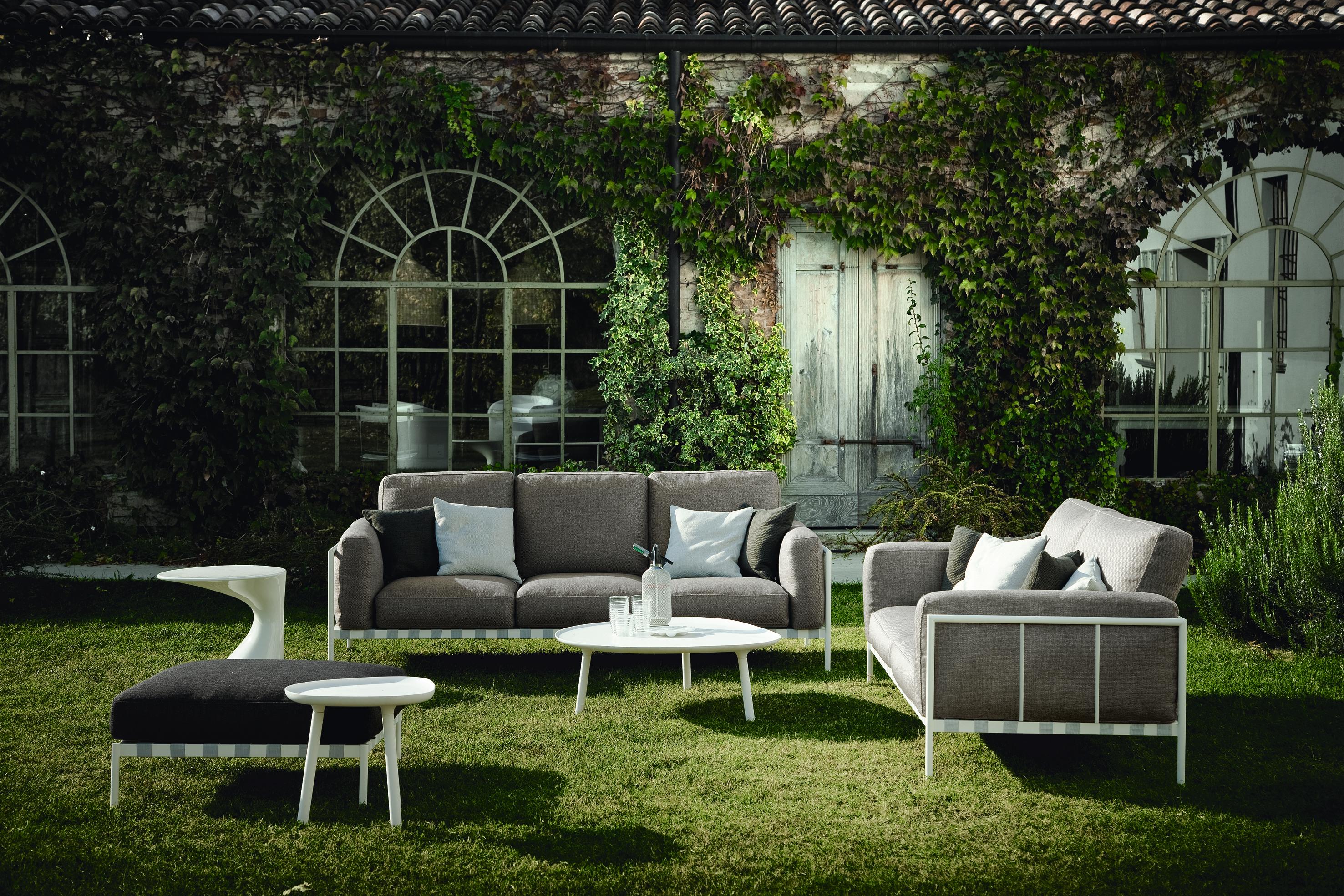 Monobloc sofas and pouf for outdoor use. Supporting frame in painted steel for outdoor use in the shade of white or black. Elastic strips suspension. Seat, back and armrest cushion in open-cell reticulated polyether/Paineira, water-repellent vegetal