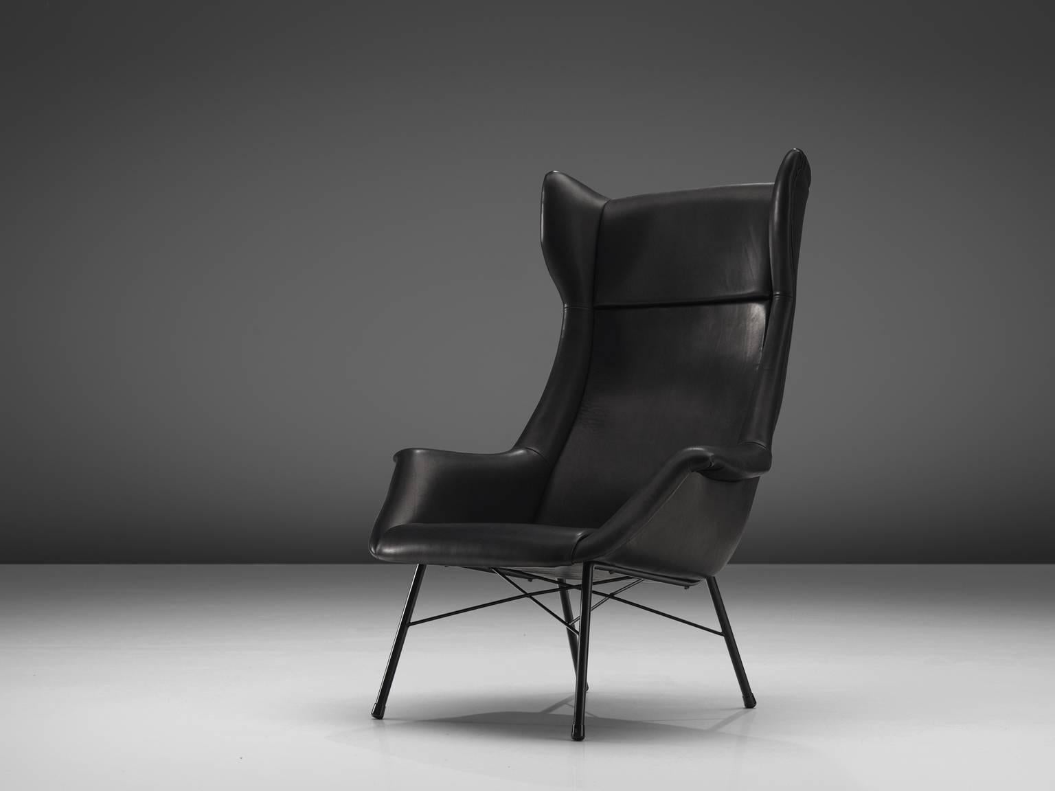 Lounge chair, black leather and metal, Czech Republic, 1950s. 

This high back lounge chair is executed in black leather and features a metal frame. This wingback lounge chair was designed by Miroslav Navratil and produced in his own atelier. The