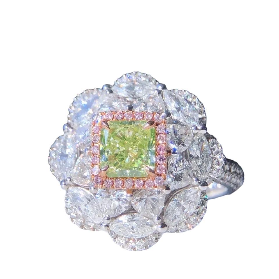 We invite you to discover this magnificent ring set with a GIA certified Fancy Green Yellow  Cut Cornered Square diamond of 1,03 carats enhanced with a halo of pink diamonds and colorless marquise and round cut side diamonds weighing 2.71 carats in
