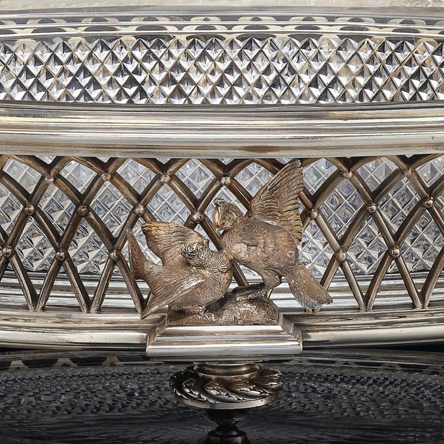 An elegant cut-crystal and silver plated centrepieceby La Compagnie des Cristalleries de Baccarat.

Stamped to the underside with the Baccarat cachet. 

This large centrepiece is of oval form with a silver-plated basketweave frame with scrolled