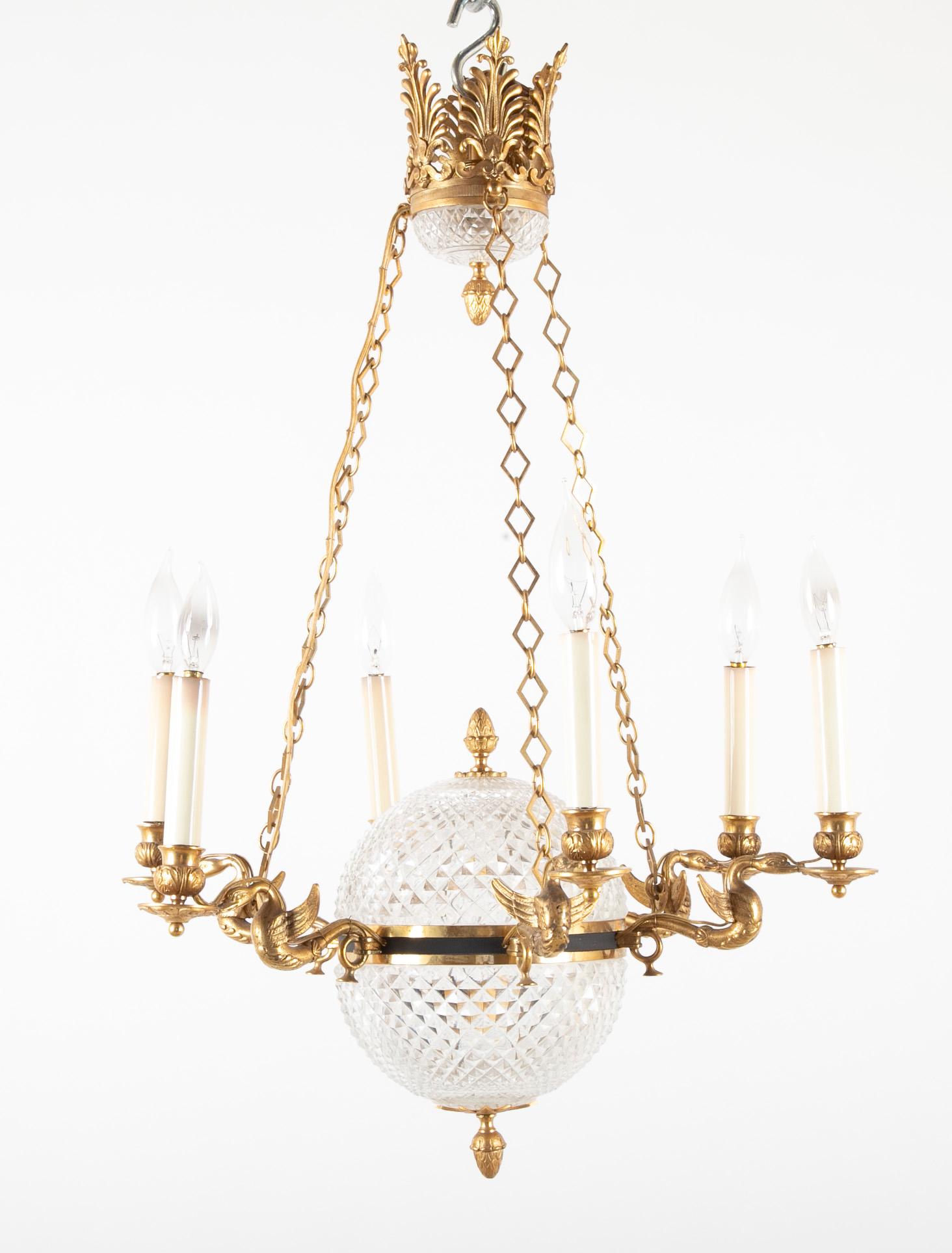 Cut crystal six-light chandelier with crystal central globe, gilded swan arms and elaborate crown.
 