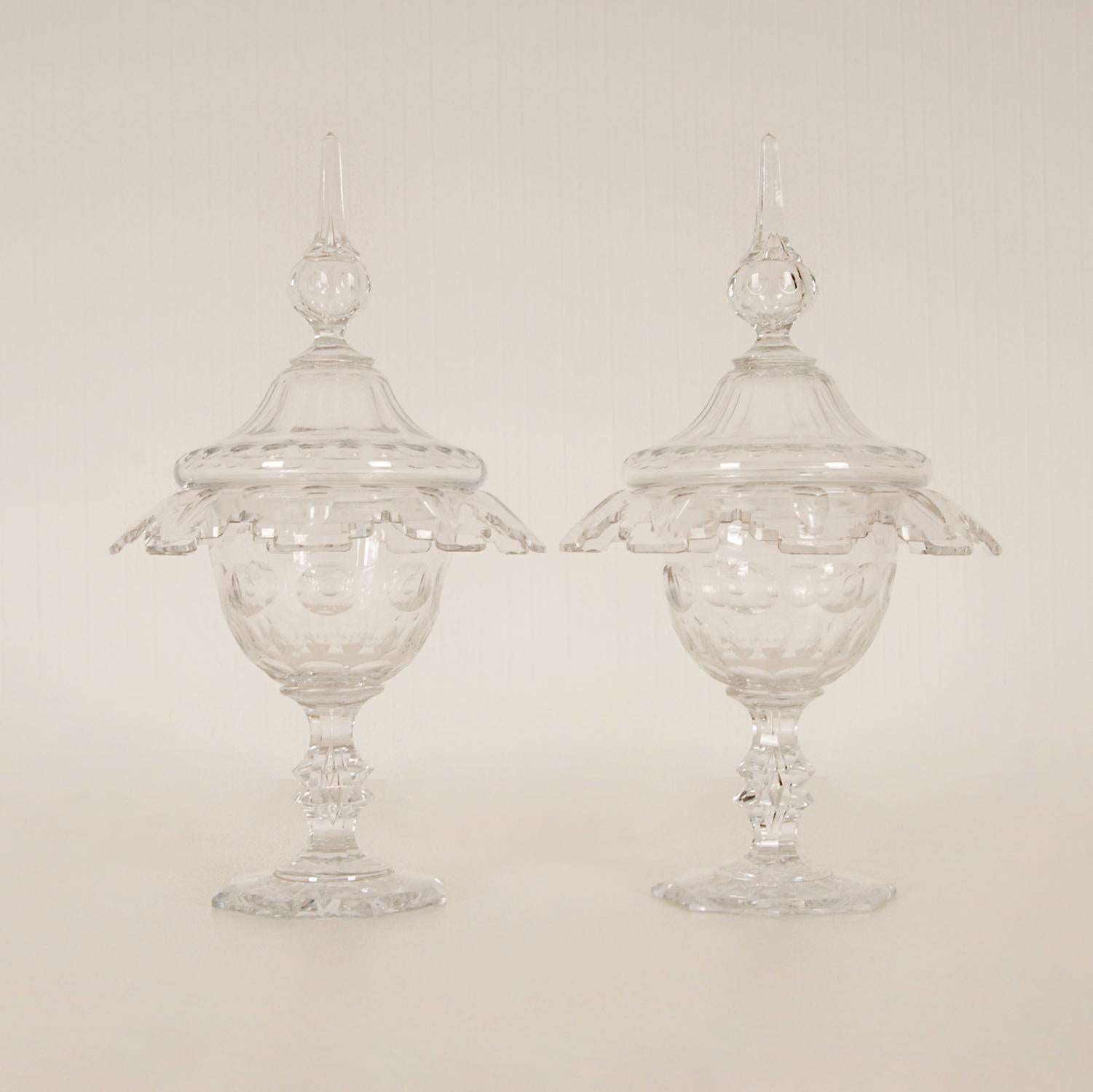 A pair of elegantly cut crystal ginger jars on foot
Victorian compotieres with a flared body and a very well done contoured edge.
The stem with a controlled air inclussion and a cut diamond knob
It rests on an octagonal base with a faceted star
The