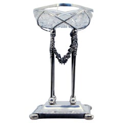 Cut crystal fruit bowl with silver frame on four flower-covered pillars