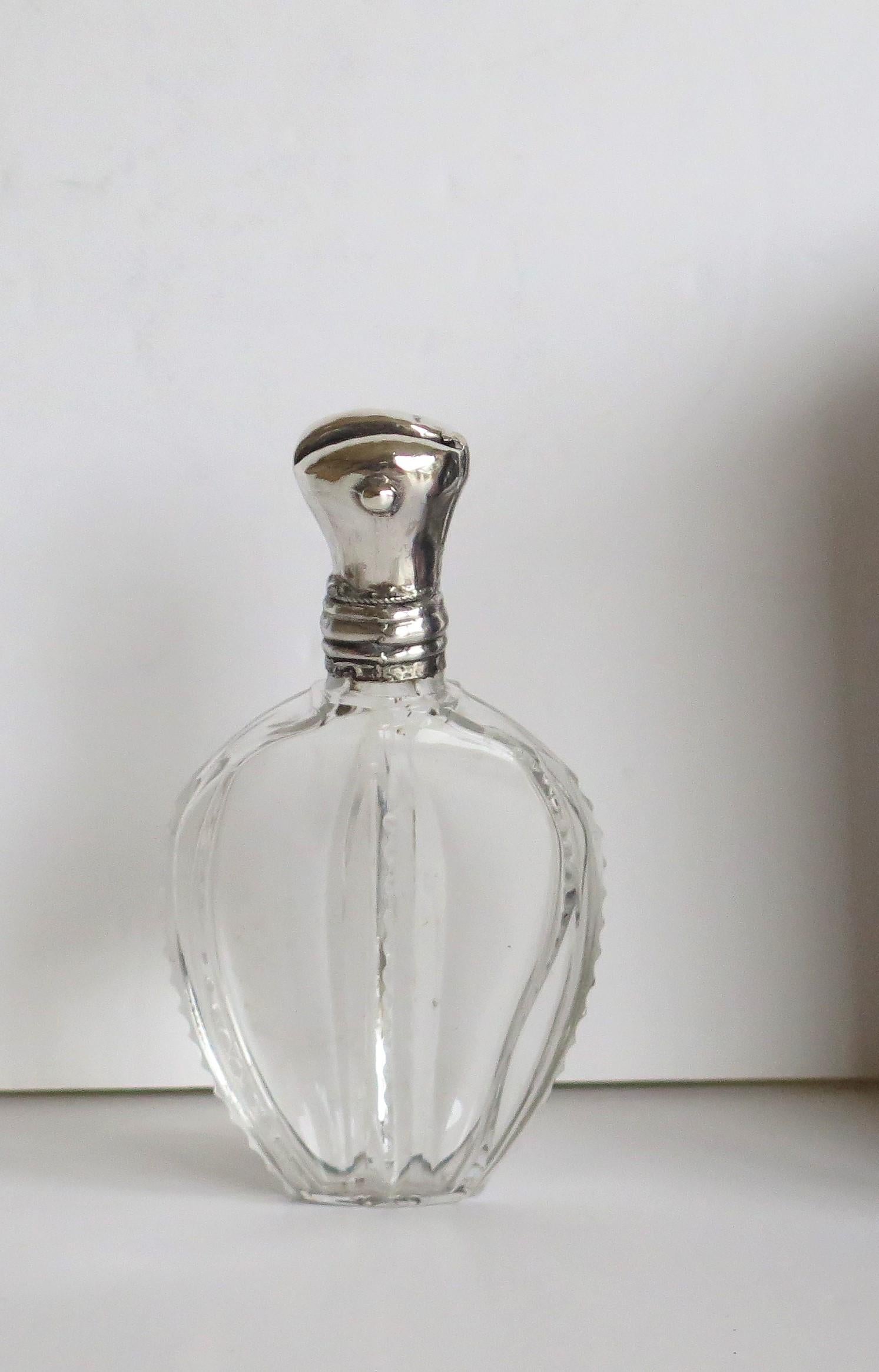 This is a good quality cut crystal glass perfume or scent bottle with a hinged silver top, very much in the Art Nouveau style, probably by a French maker and dating to the late 19th century, circa 1880.

The crystal cut glass bottle has an elegant