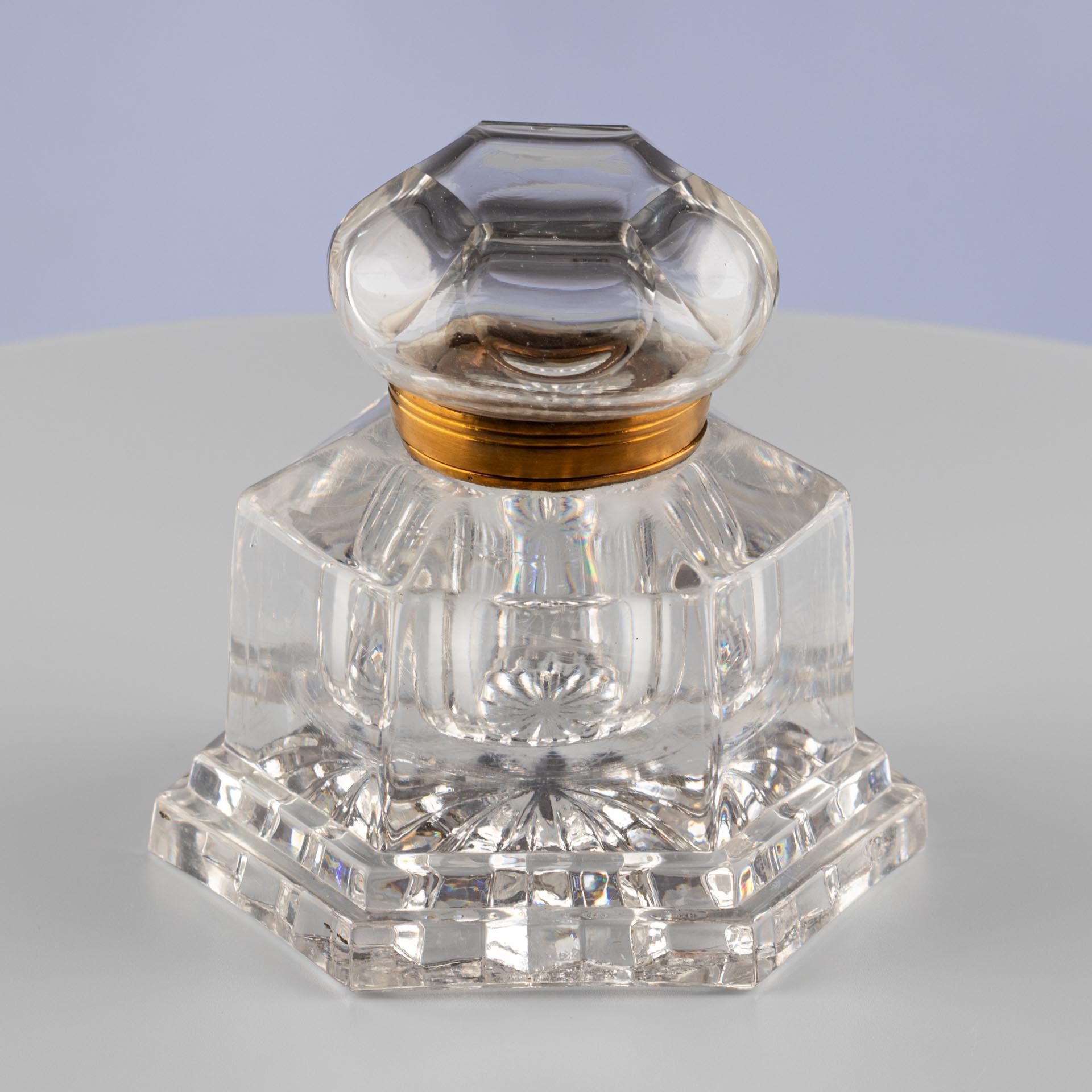Cut Crystal Inkwell with Faceted Hinged Lid

Origin: likely Central Europe
Material: colorless lead crystal, brass
Date: circa 1900
Dimensions: H × W × D: 11 × 11 × 11 cm

Description:
Hexagonal desk inkwell made of solid, colorless lead crystal