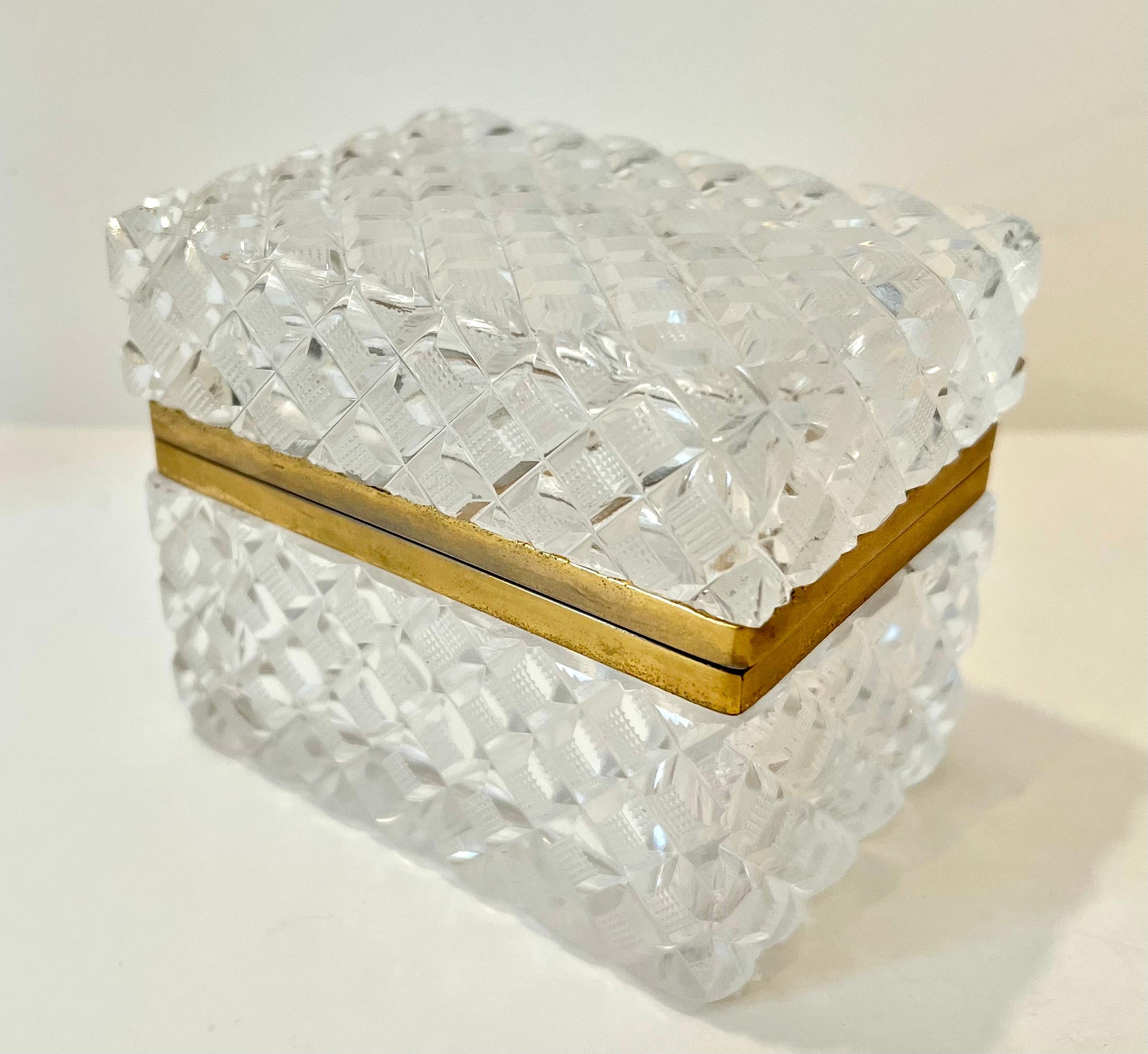 Boîte à couvercle en cristal - rectangulaire avec des carrés taillés et des surfaces texturées.  Un complément à toute table de cocktail, poste de travail ou bureau. 

Nombreux usages - également idéal dans le bain comme porte-boules de coton.  chic