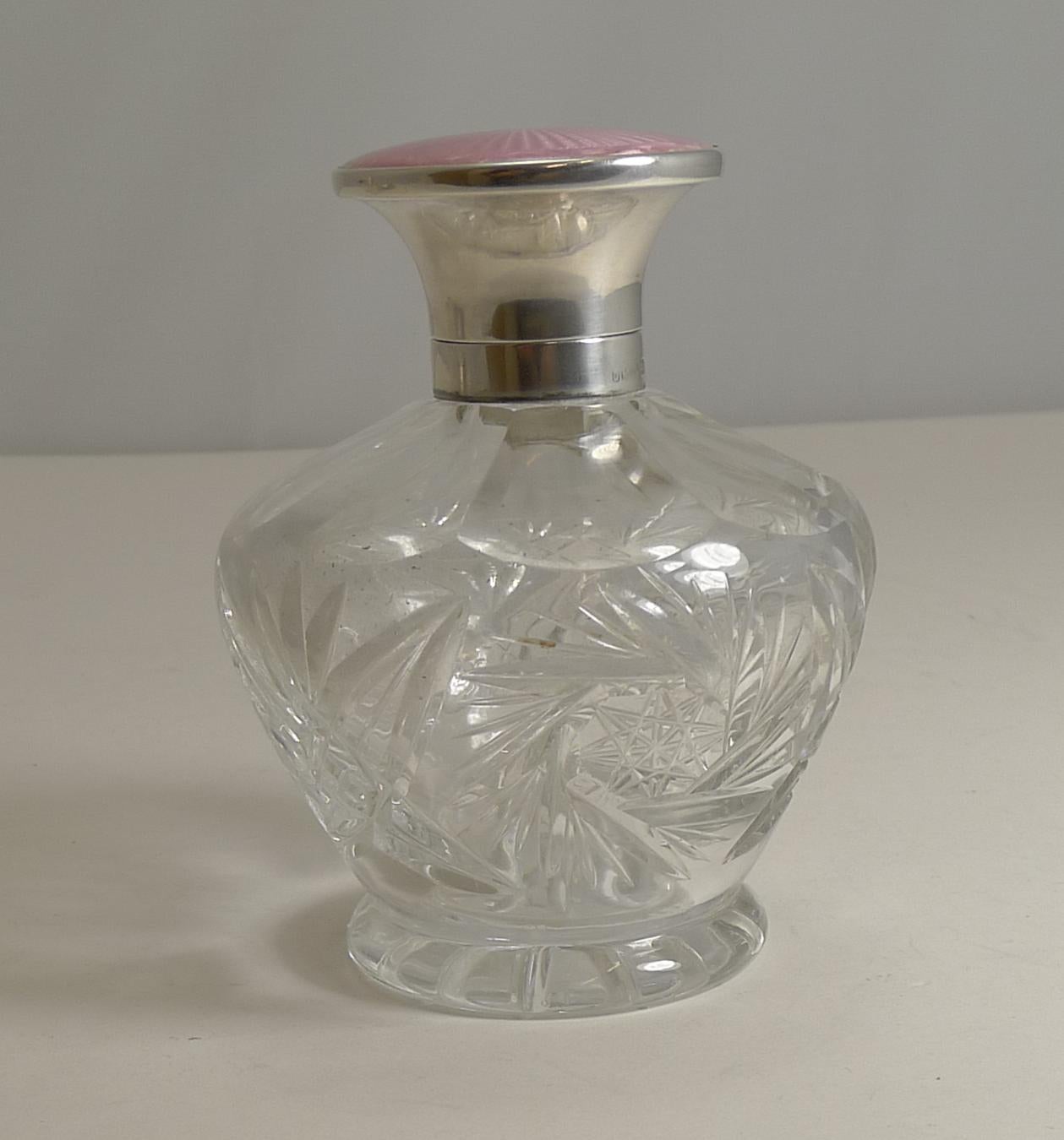 Without doubt, pink guilloche enamel is the number one desired color, hard to come by and always at a premium.

A hefty piece of English crystal has been used to create this pretty bottle, handcut in a pretty design with a star-cut to the