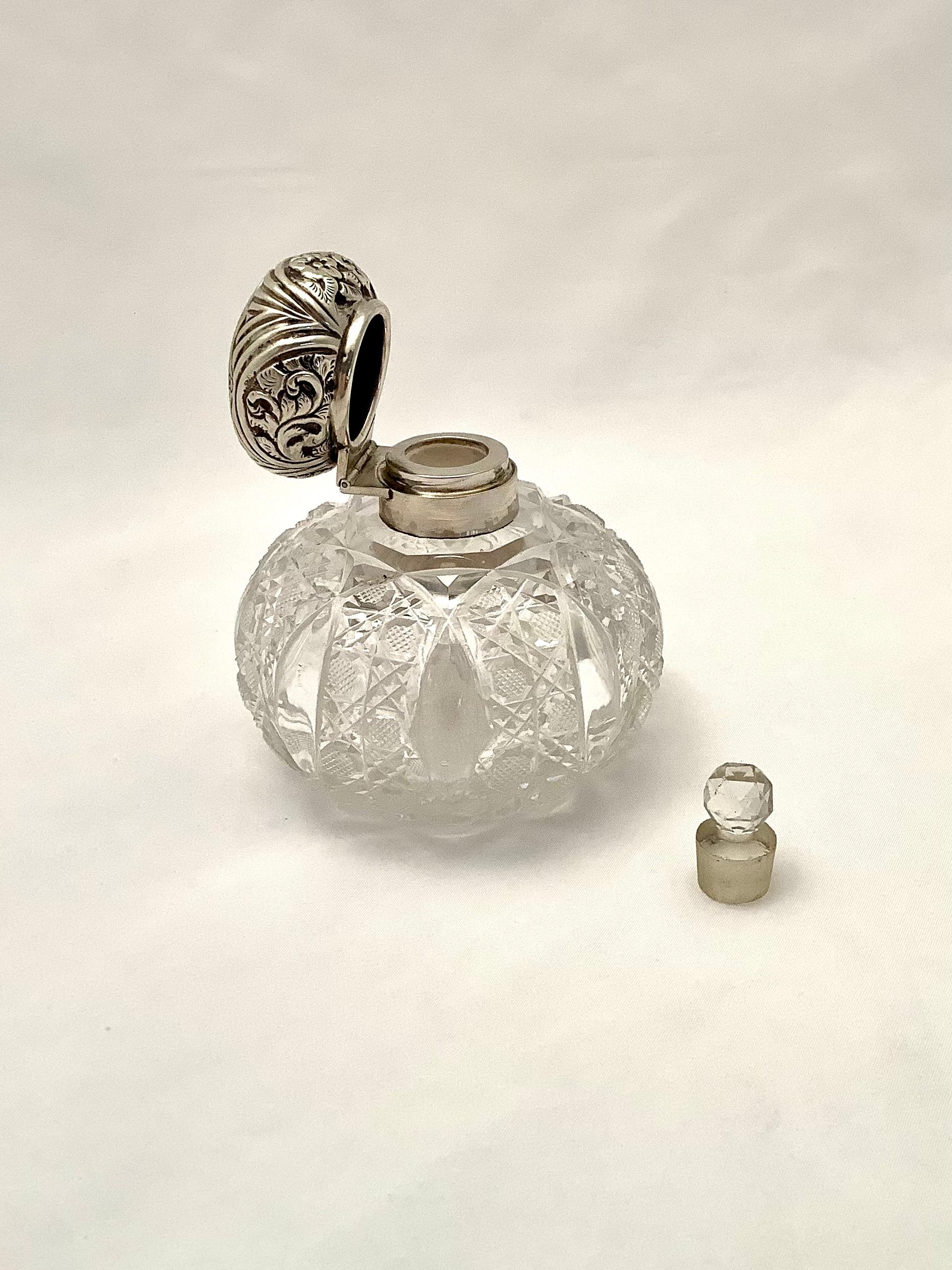 Early 20th century Victorian style cut crystal perfume bottle with sterling silver lid.  Original stopper enclosed.  Great condition. Stamped hallmark on silver lid.