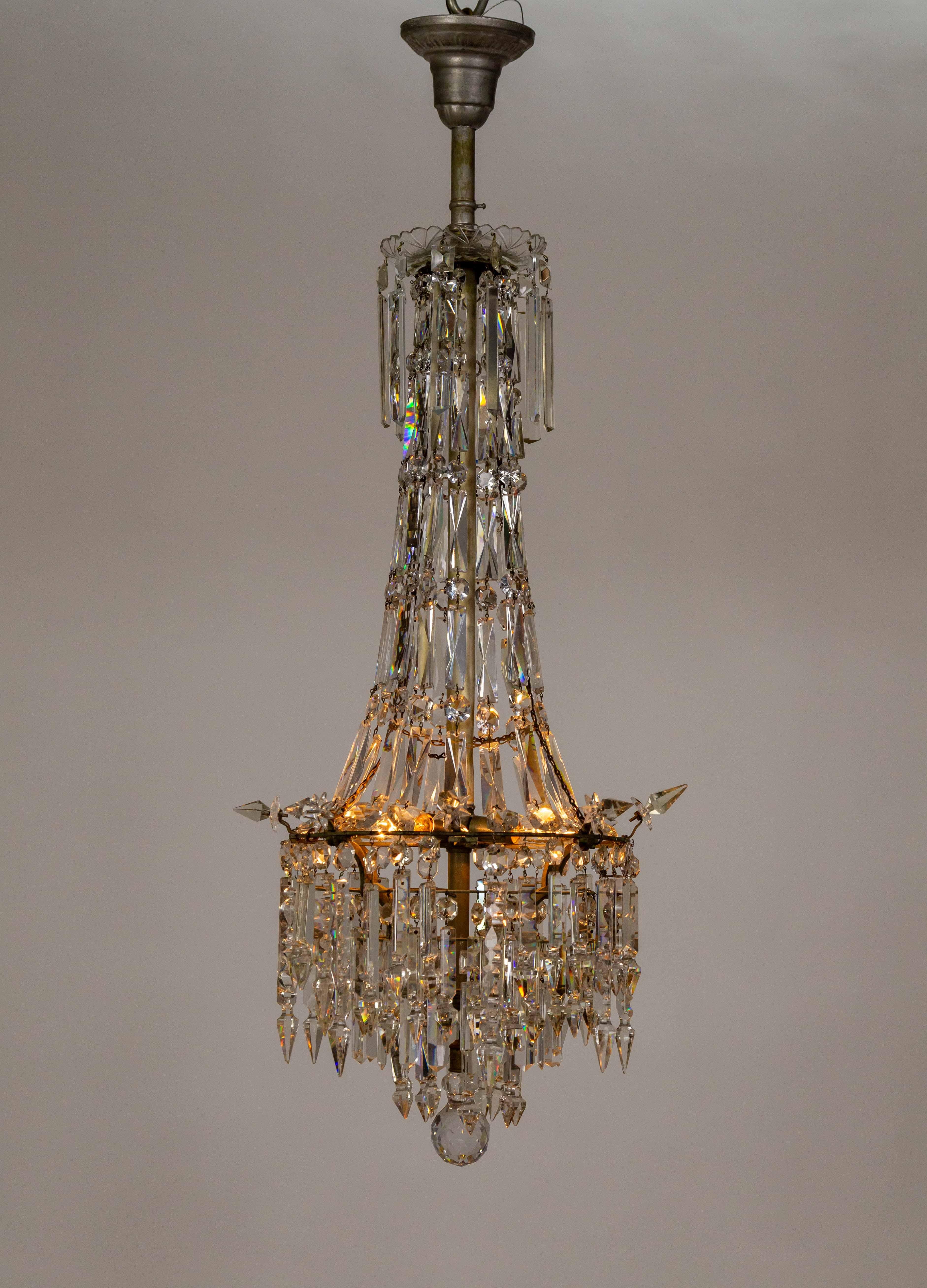 This chandelier is truly stunning, with its sparkling, leaded glass cut crystals. An Empire-style crystal chandelier in the form of a tent with a ring structure adorned with outward-facing spears and concentric rows of dangling crystals. The