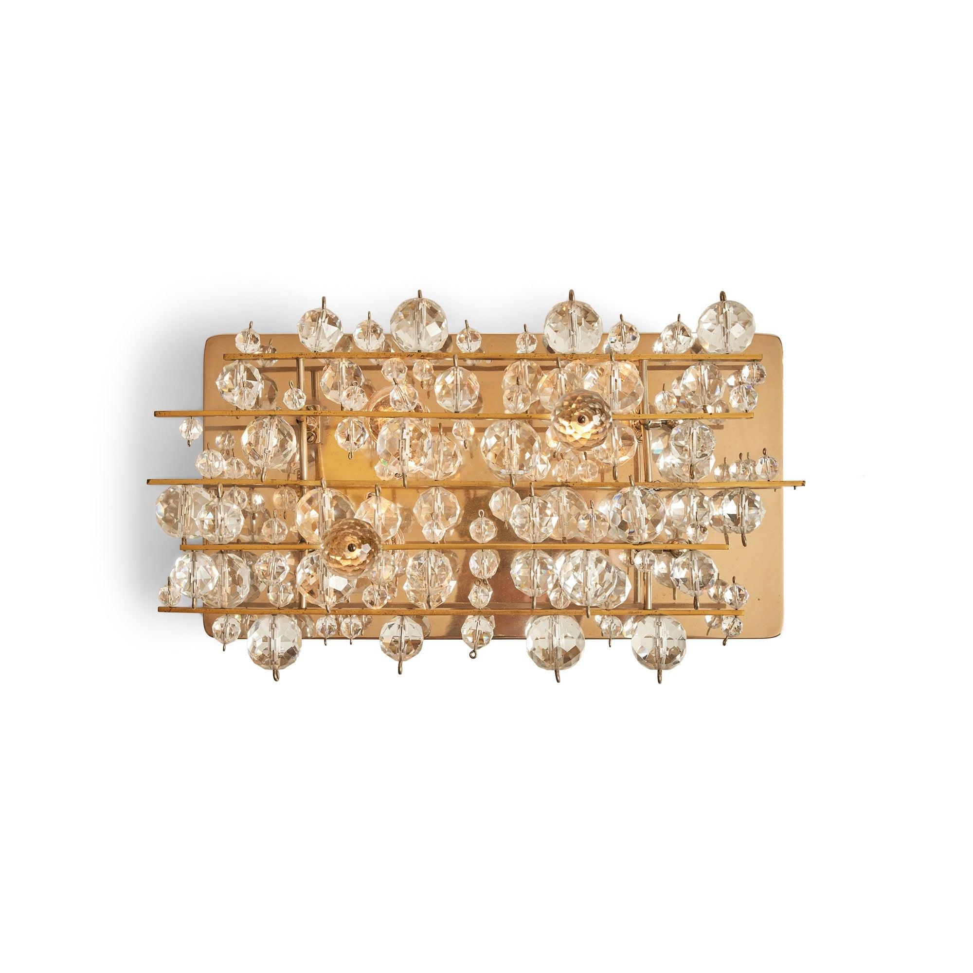 Aplique o candelabro de pared con una placa trasera niquelada y una armadura de latón que sostiene una serie de bolas flotantes de cristal facetado de distintos tamaños.