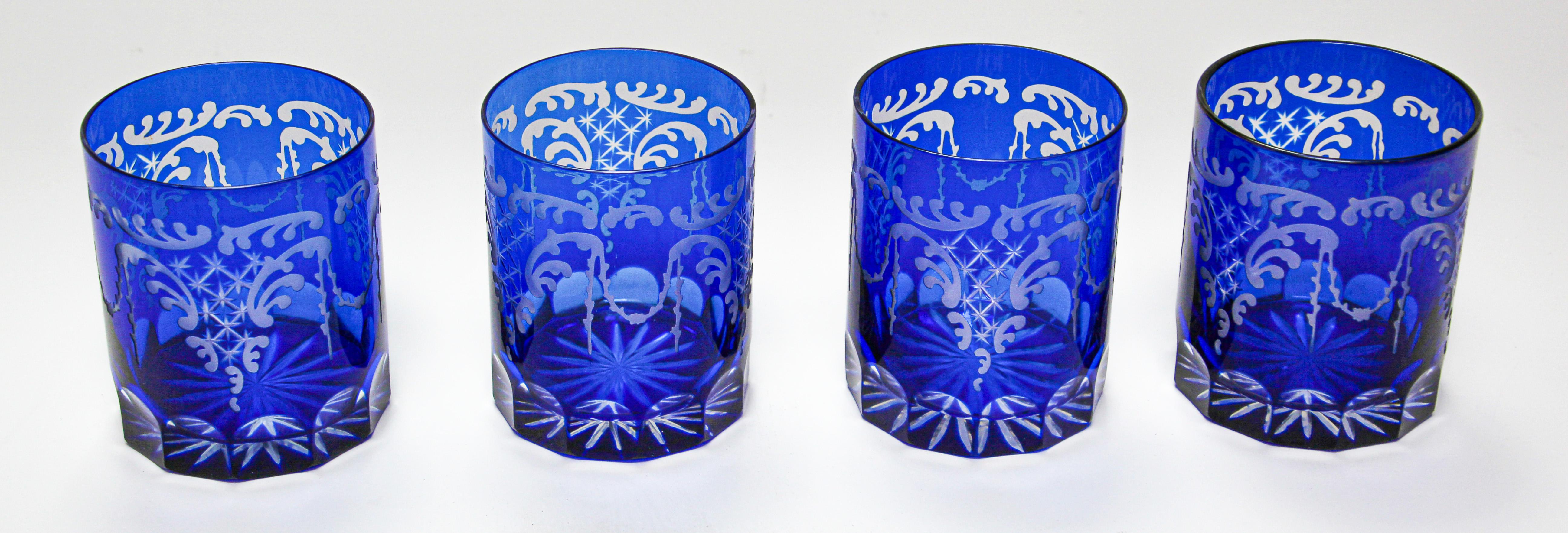 Set of four whiskey glasses tumbler cobalt blue crystal Baccarat style. 
The vibrant hand blown rich sapphire blue jewel sapphire blue crystal glass is cut to clear to reveal a lovely pattern with clean lines. 
Set of four rock whiskey or water