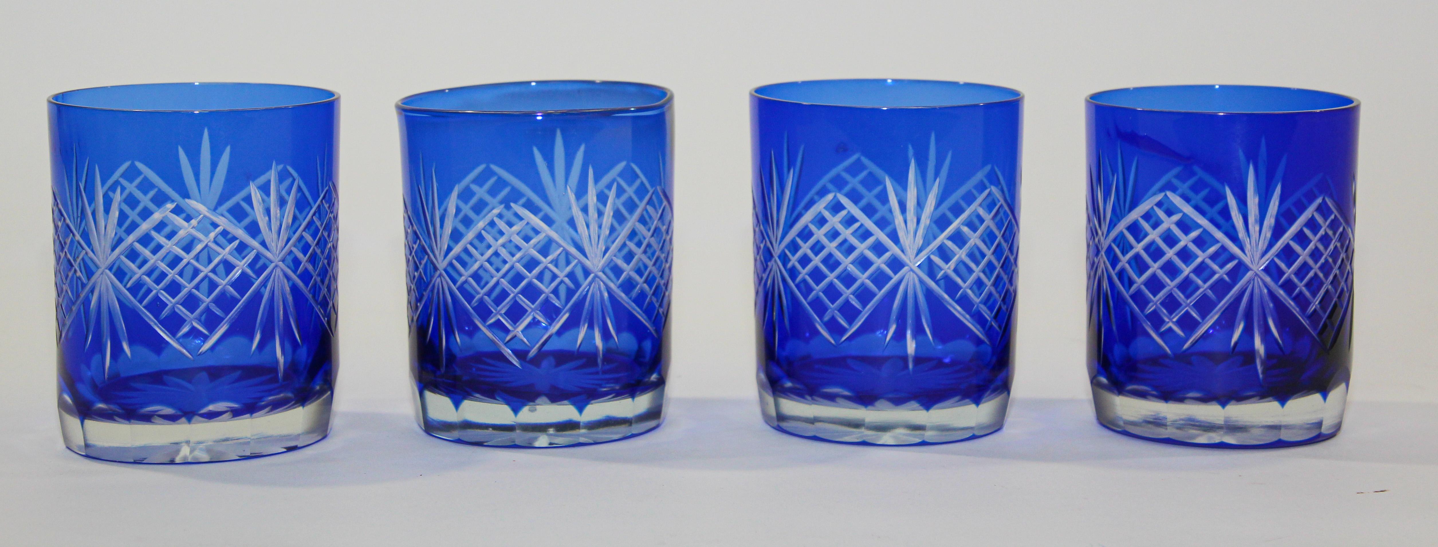 Set of four vintage whiskey glasses tumbler cobalt blue crystal Baccarat style. 
The vibrant hand blown rich sapphire blue jewel sapphire blue crystal glass is cut to clear to reveal a lovely pattern with clean lines. 
Set of rock whiskey juice or