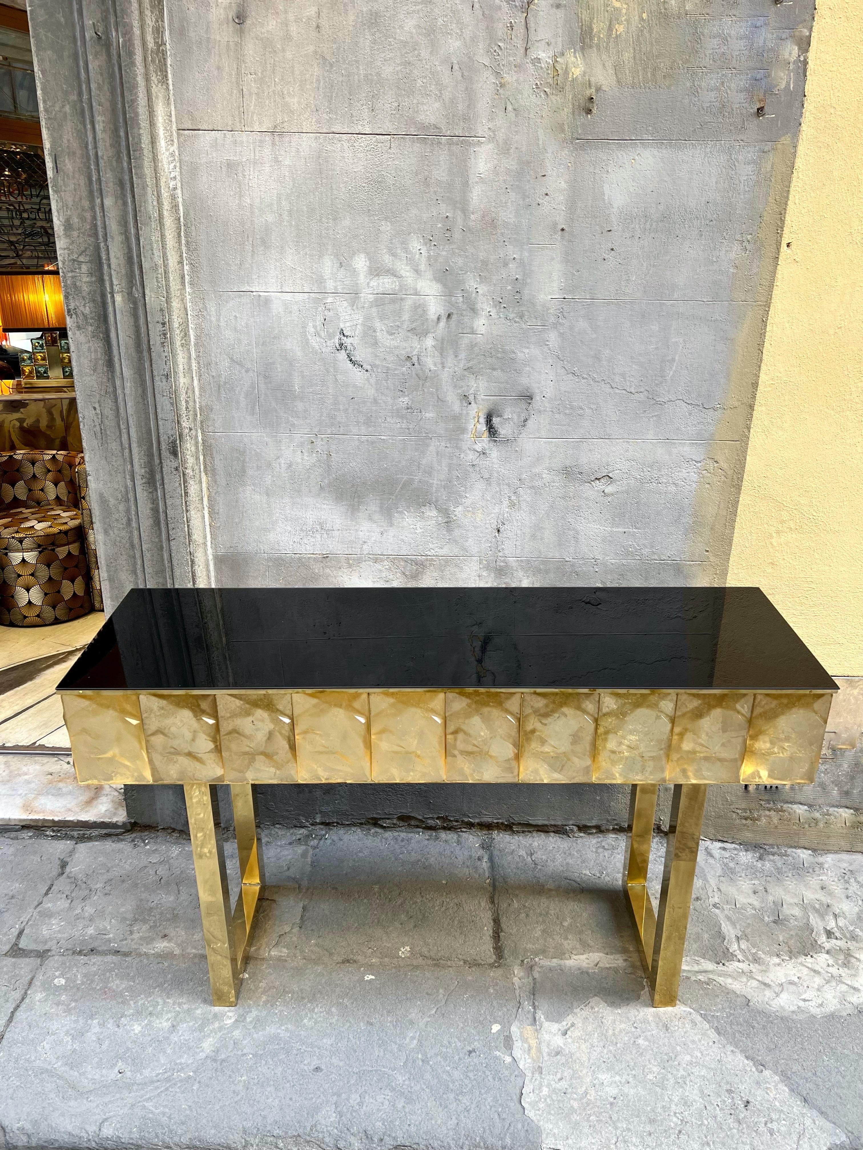 Contemporary cut diamond shape gold murano glass console with black opaline glass top and brass structure.
The Gold Murano glass has a faceted shape diamond effect, the light passing through creates an amazing sparkling effect.
Italian Design,