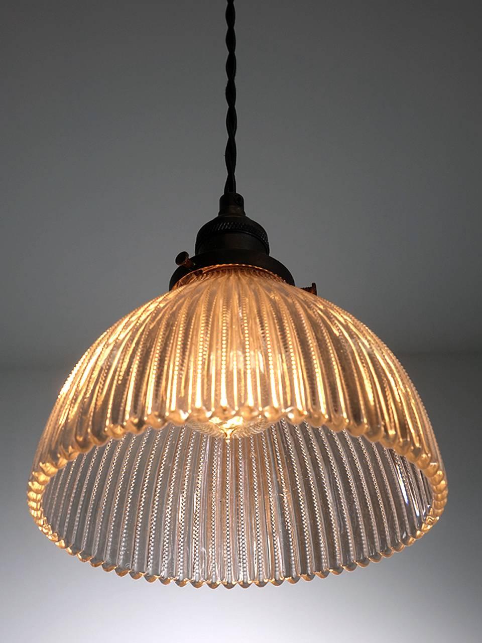 Ce sont de jolis petits pendentifs Holophane avec un aspect unique de verre taillé. Cette collection est un peu plus décorative que le verre prismatique standard. Il présente une fine série de coupes sur les bords élevés qui capturent le verre de