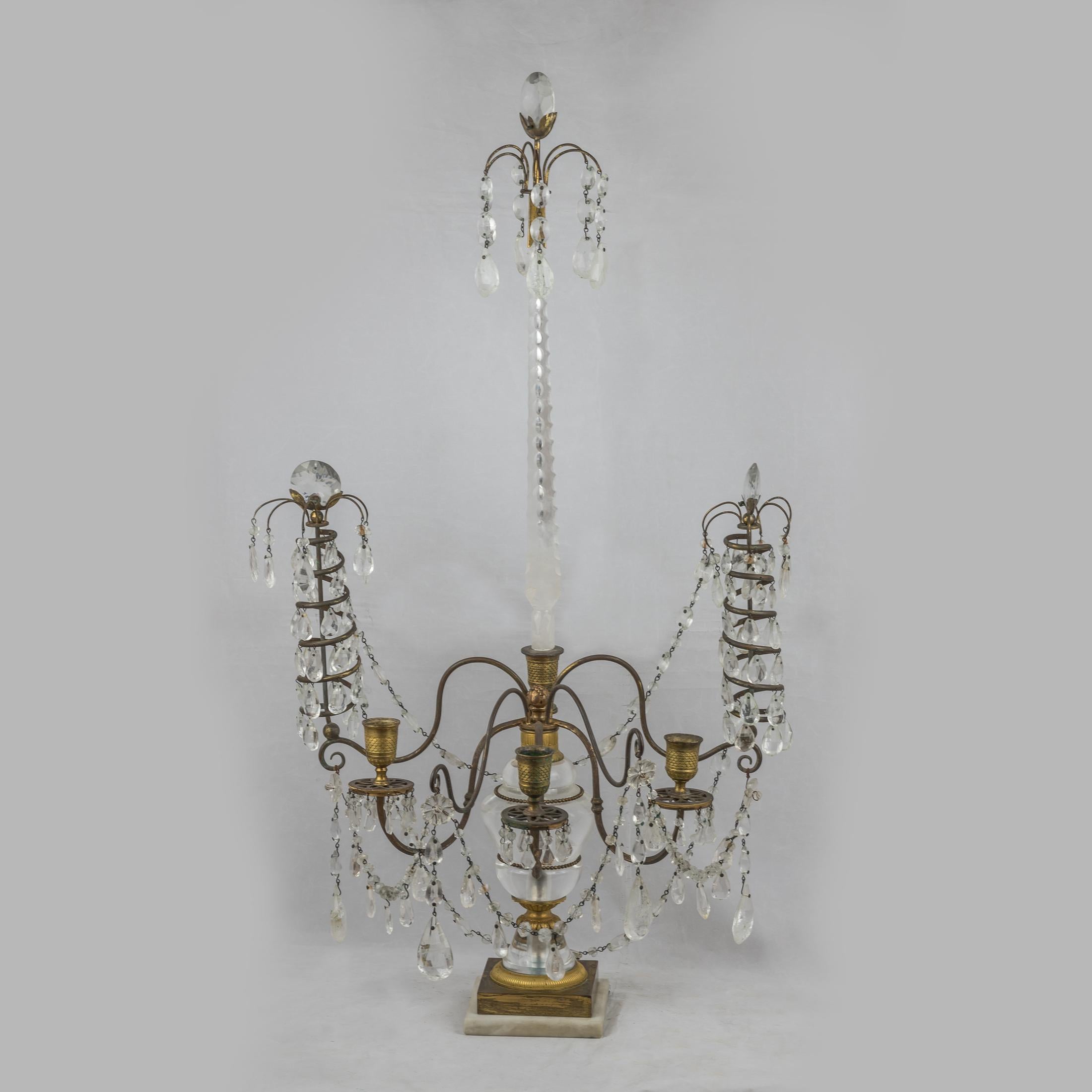 A fine pair of Baltic neo-classical cut glass mounted ormolu, rock crystal and white marble three-light candelabras.

Origin: French
Date: 19th century
Dimension: 30 1/2 in x 16 1/2 in.