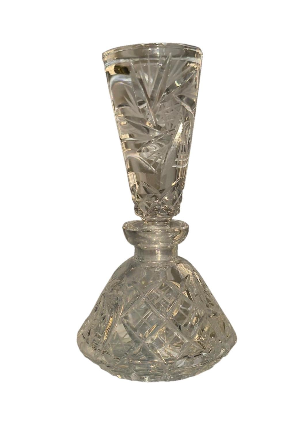Dieser elegante und zeitlose Parfümflakon aus geschliffenem Vintage-Glas fängt den Glanz der alten Welt der Eitelkeit ein. Der mit Präzision gefertigte Körper weist ein strahlendes geometrisches Schnittmuster auf, das das Licht in alle Richtungen