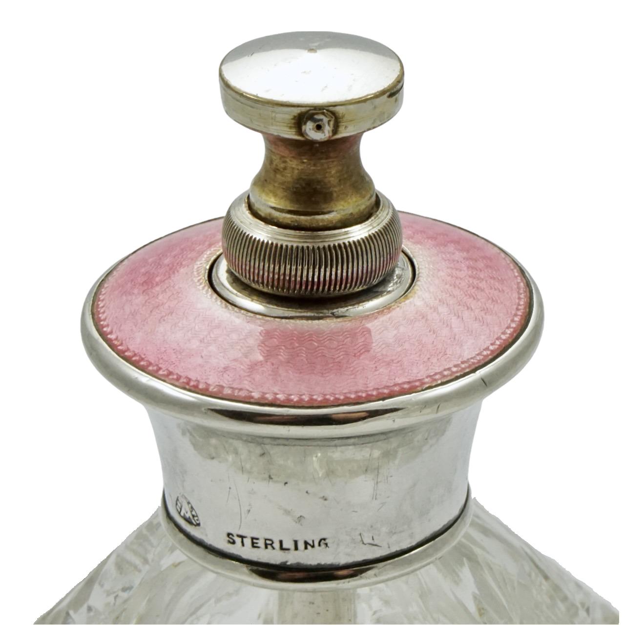 
Beautiful cut glass perfume bottle in a classic design featuring a sterling silver top decorated with pink guilloche enamel. The sprayer screws down when not in use. Measuring height 9 cm / 3.5 inches by diameter 7 cm / 2.75 inches. The perfume